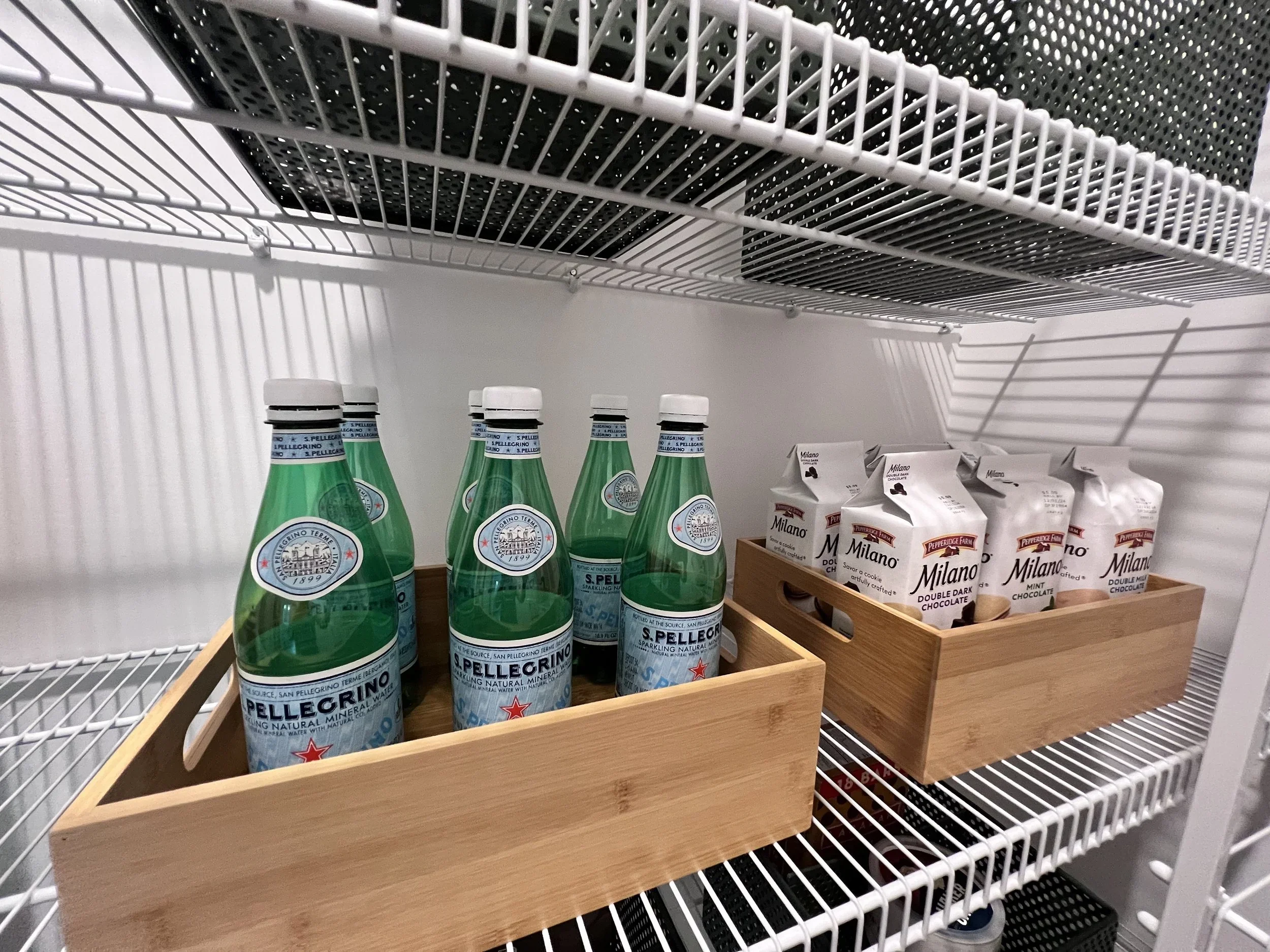 Professional pantry organization by Custom Order Home Organizing in the Quad Cities, featuring S.Pellegrino bottles and Milano cookies in bamboo bins.