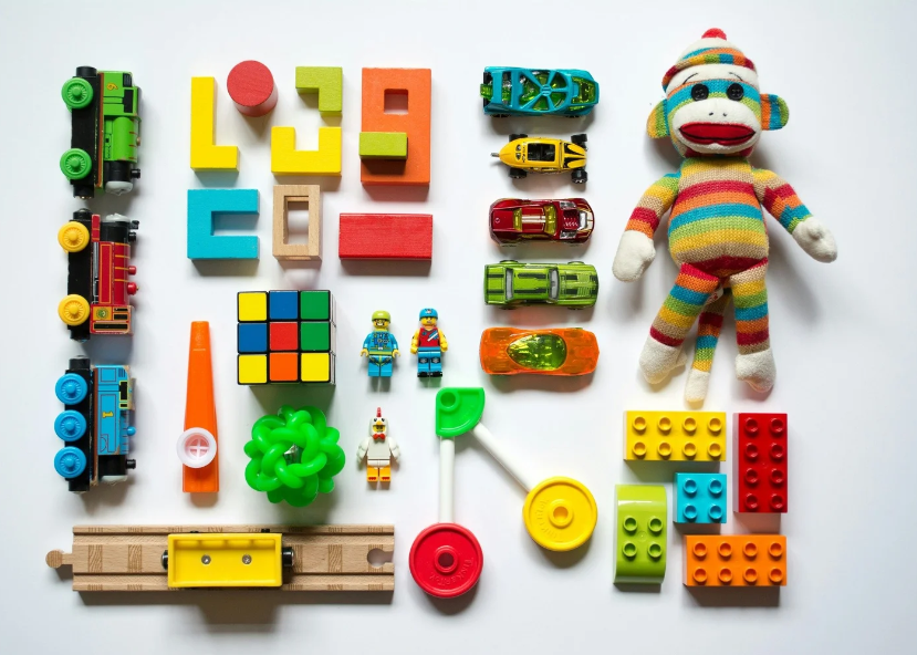Professional toy organization in San Antonio by Amélie Organizes, featuring a sock monkey and colorful blocks neatly arranged on a white background.