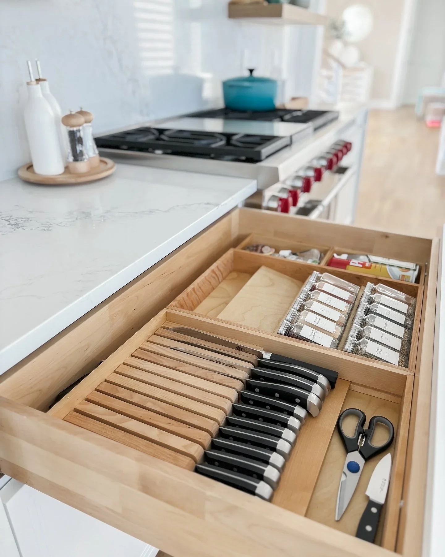 Professional kitchen drawer organization by Orderly at the Shore in Jersey Shore, featuring a custom wooden insert for knives and uniform spice jars.