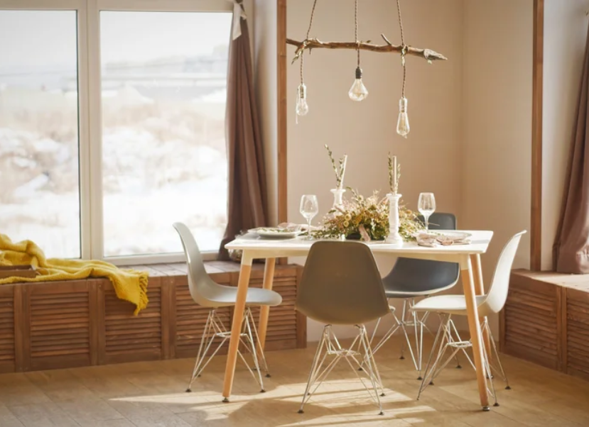 A bright, minimalist dining room styled by Joyful Order Organizing in Asheville, featuring a branch chandelier and mid-century modern chairs.