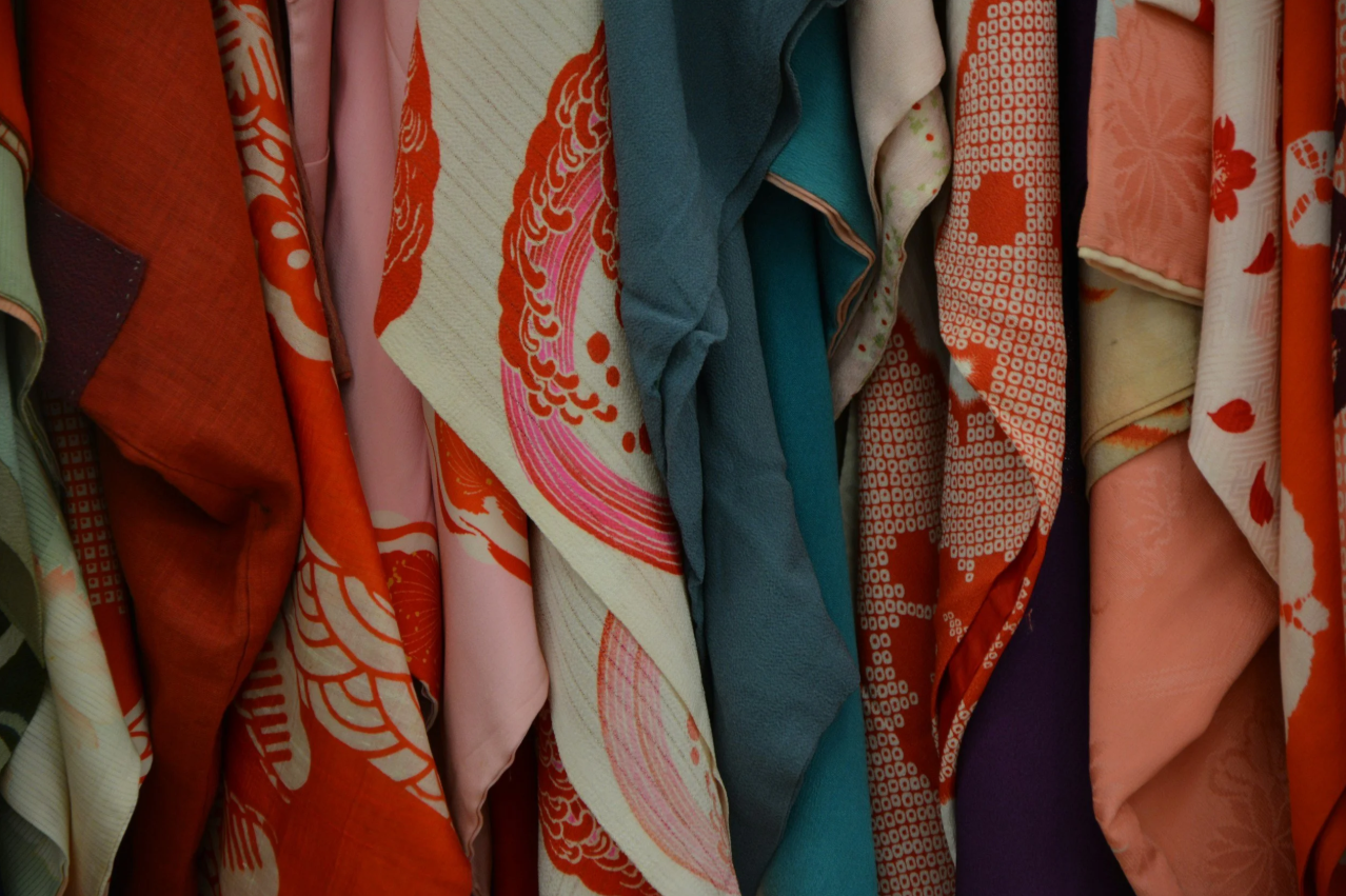A close-up of vibrant, patterned fabrics and garments hanging together, showcasing professional closet organization by An Neater Place.