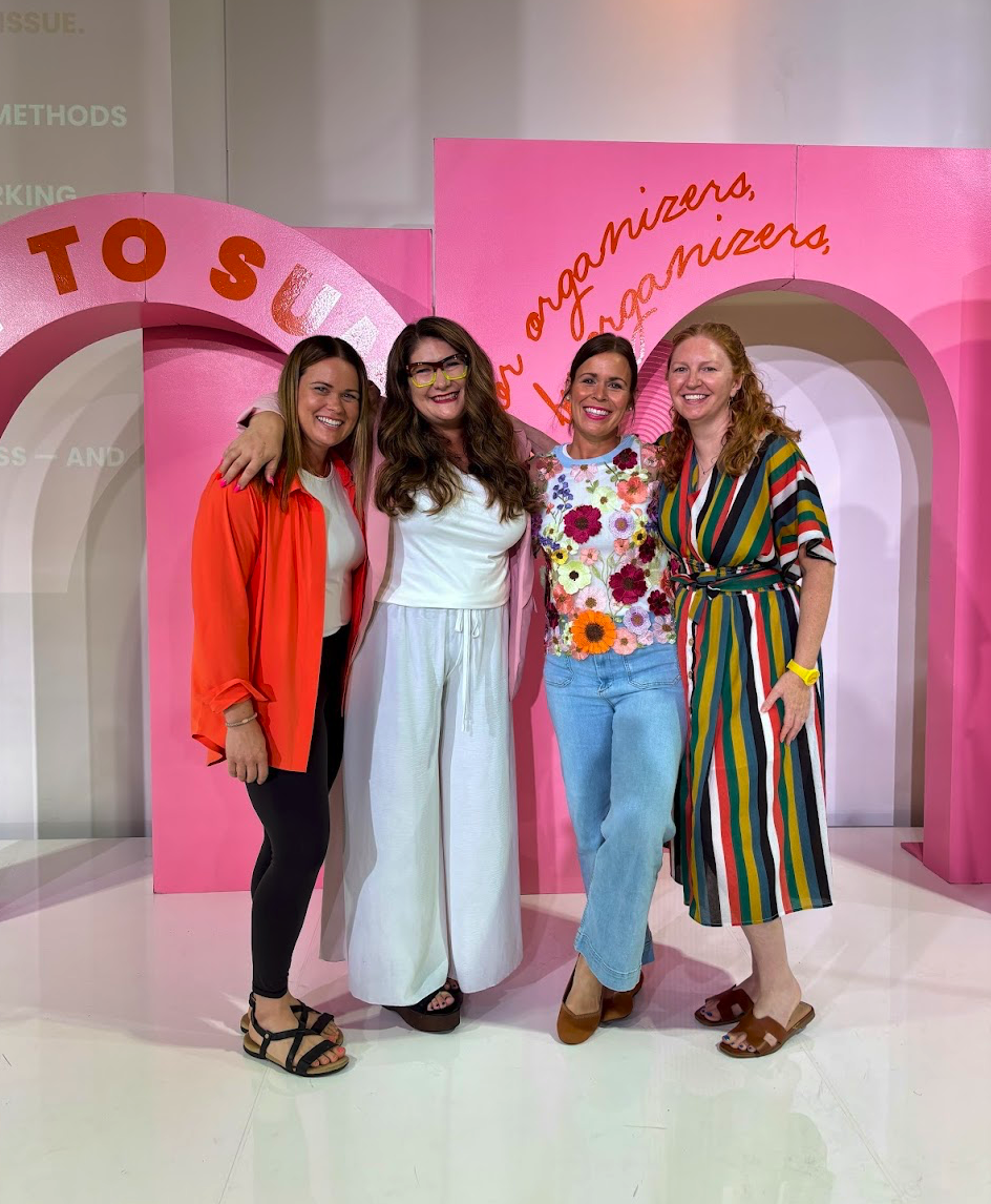 Pro Organizer Studio founder Jen Kilbourne and team at the How To Summit conference, standing in front of a pink 'Road to Success' backdrop.
