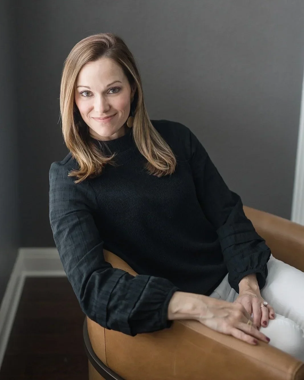 Founder of At Home Organizing smiling in a minimalist living space.