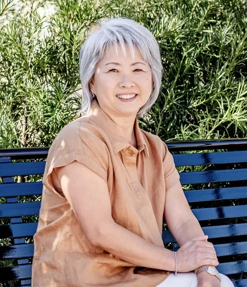 Professional home organizer Makiko Hoff smiling outdoors on a bench.