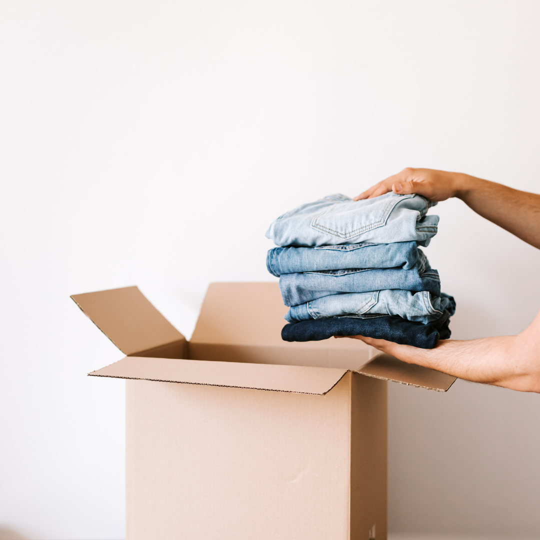Professional organizer from Sugar & Space packing folded blue jeans into a cardboard box for a move in Blaine, WA.