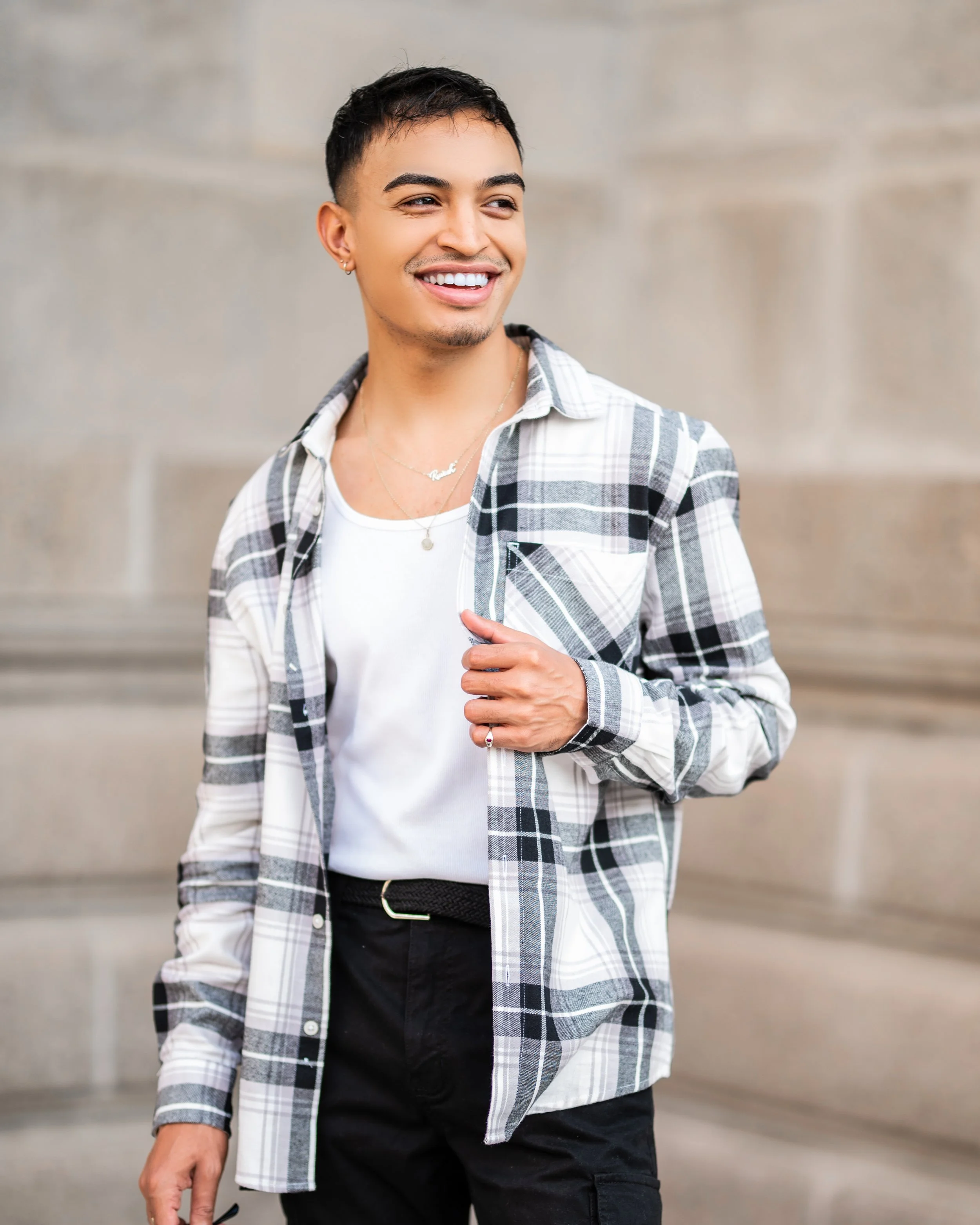 Man in plaid shirt smiling outdoors. Photographed in Auckland Park, Johannesburg.