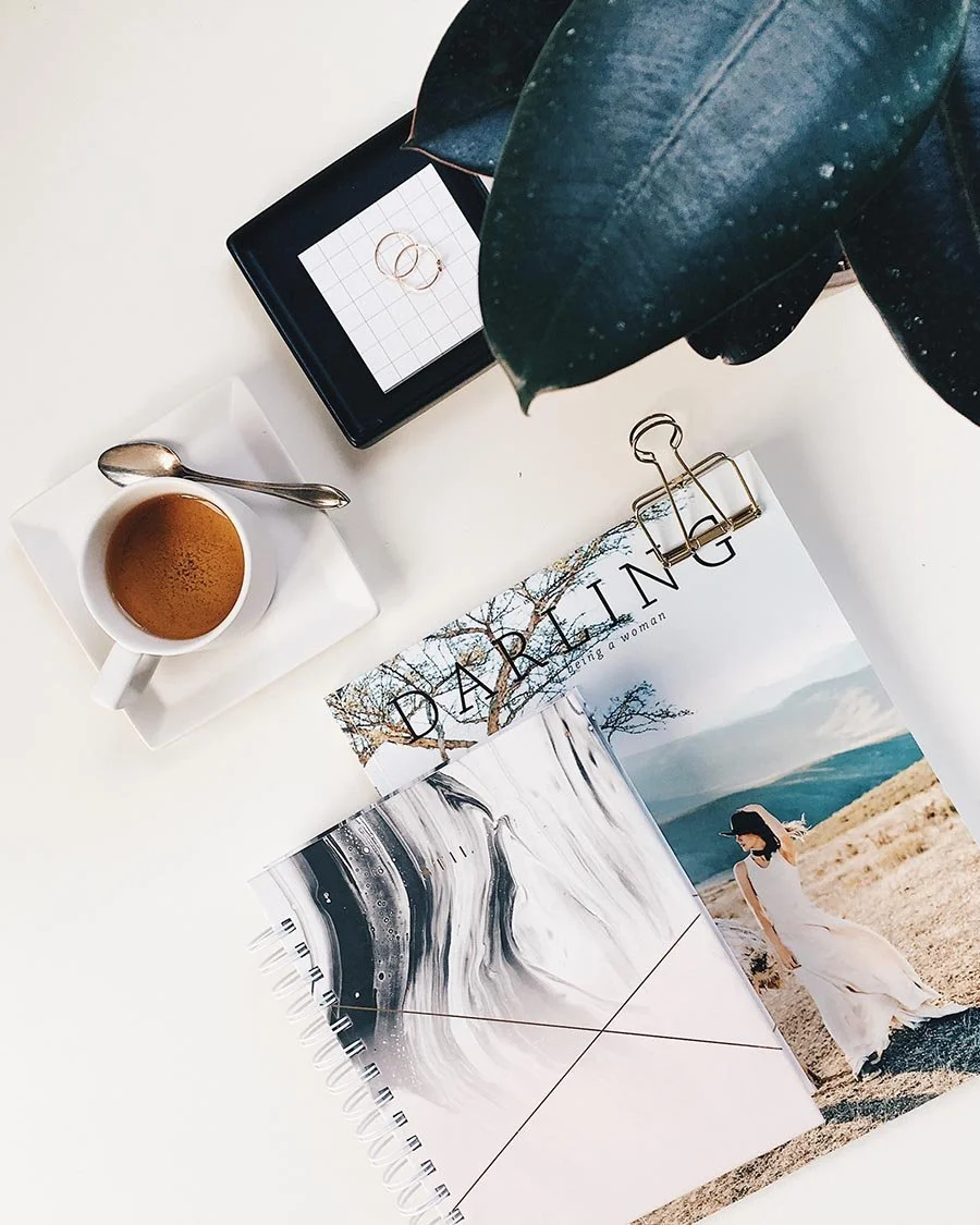 Photo of magazine and notebook with coffee on desk