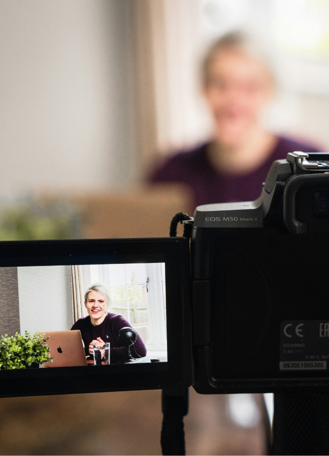 Photo of woman recording video on a camera
