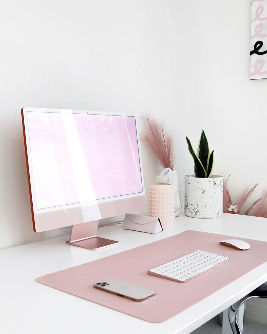 Photo of desk with pink iMac and desk accessories