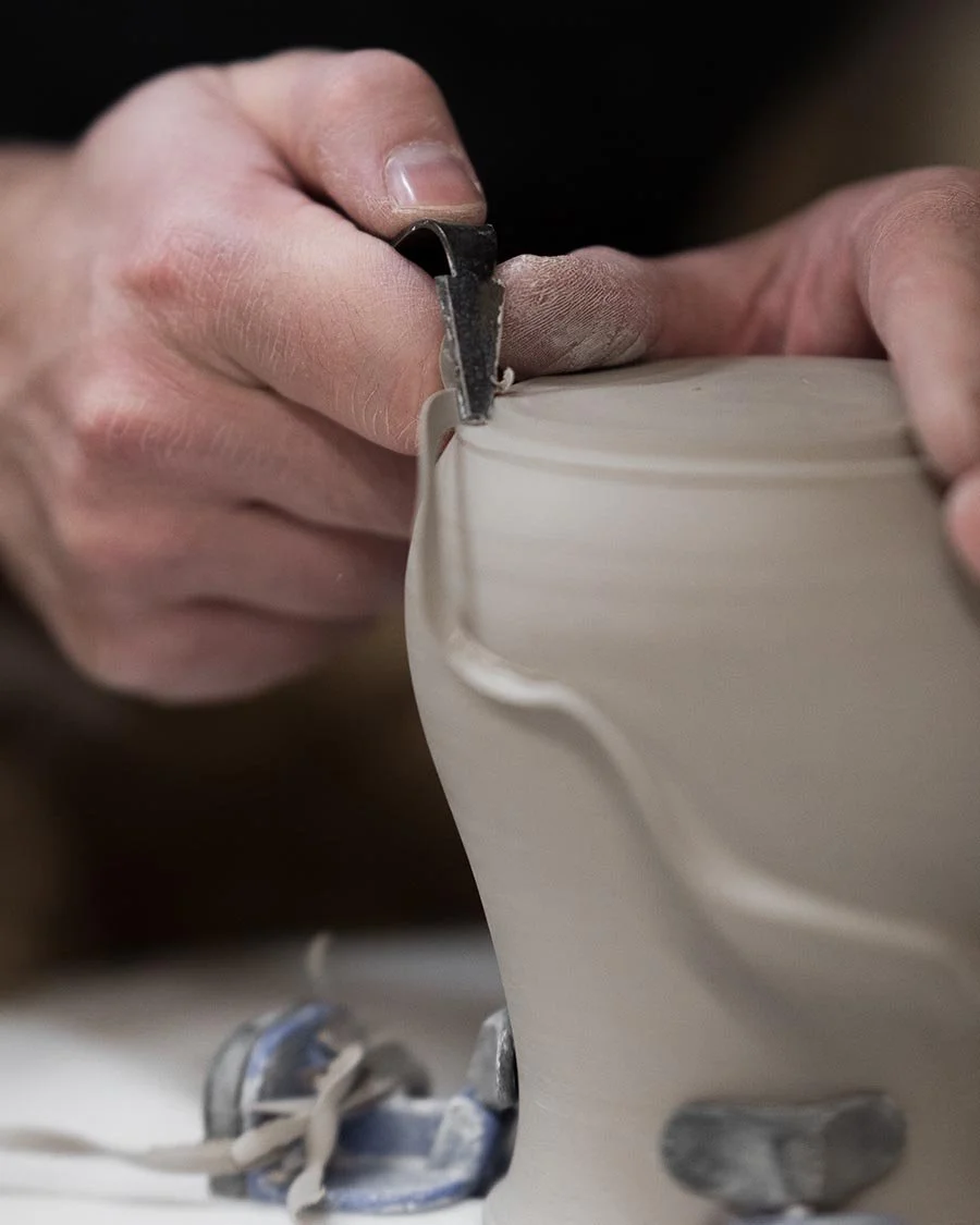 Photo of someone trimming a clay pot