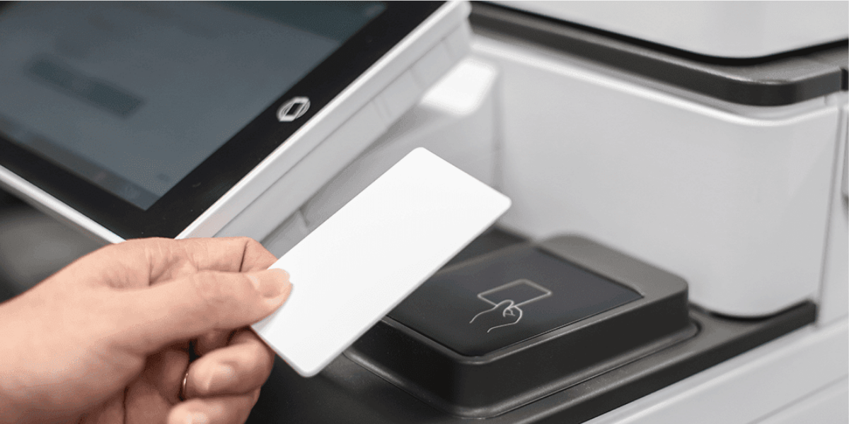A user releasing a print job by tapping an ID card at a multifunction printer in a school