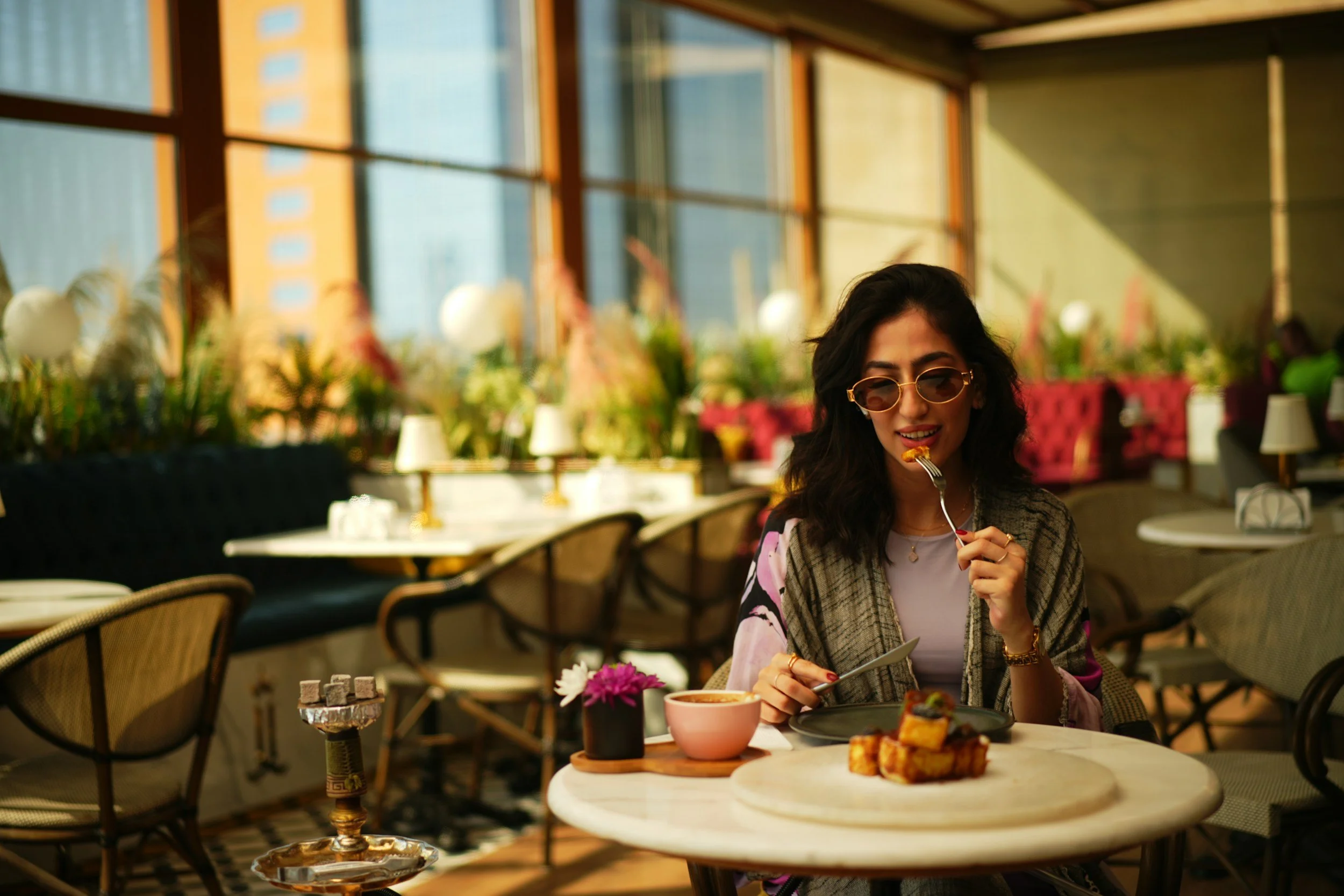 Woman eating alone wearing glasses, at a resturant,