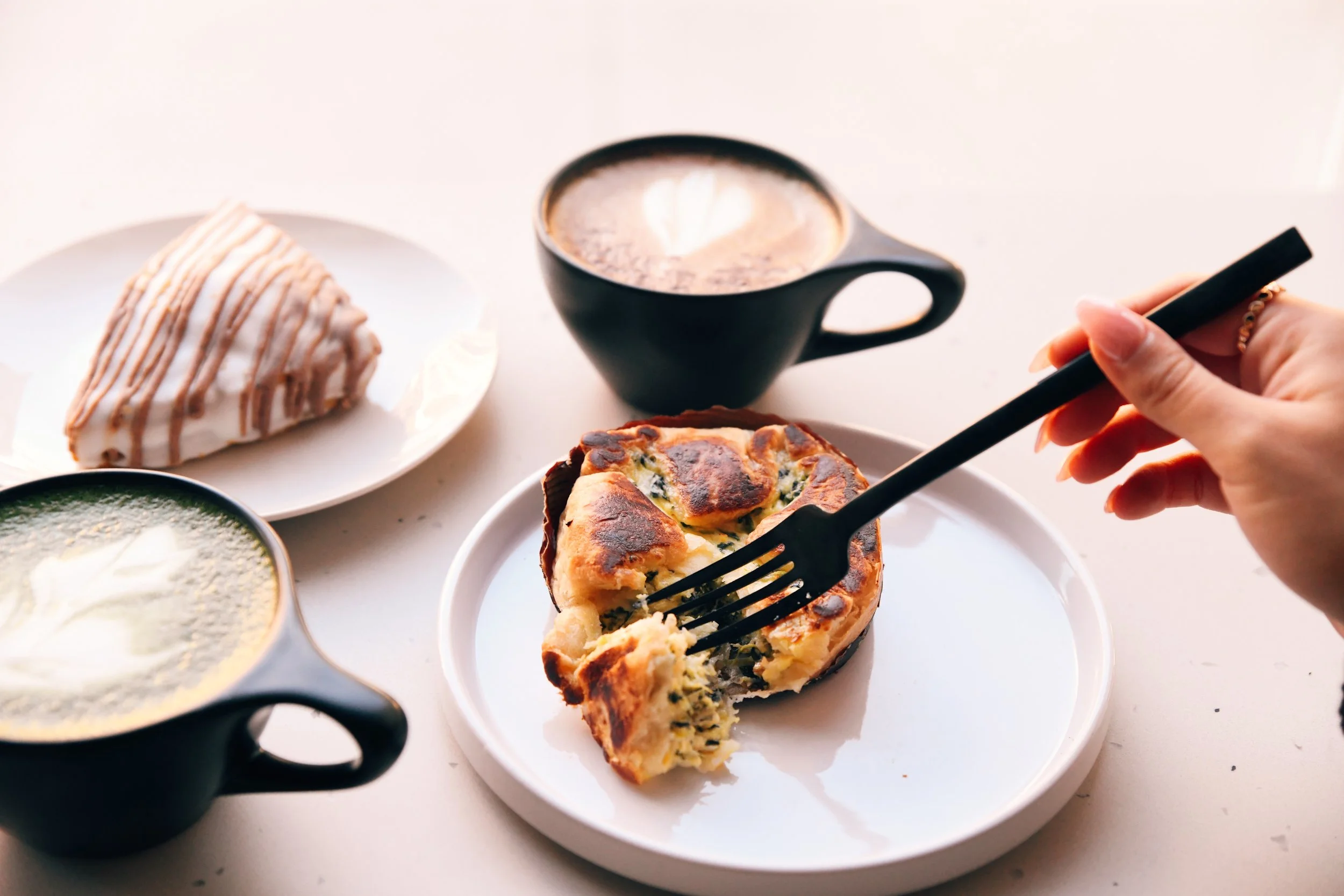 Black coffee mug with Outpost Coffee logo on a wooden counter surrounded by similar mugs.