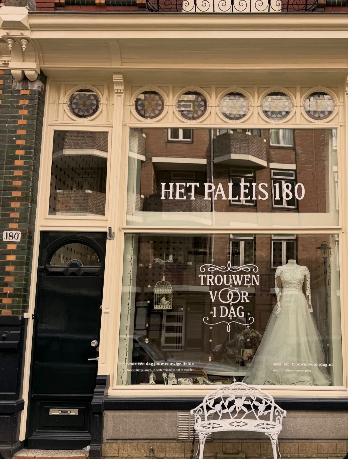 Een winkel met een grote raamposter die een trouwjurk toont en de tekst 'HET PALEIS 180' en 'TRouwen VOR 1 DAG'.