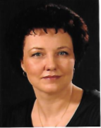 Porträt einer Frau mit dunklem, lockigem Haar vor schwarzem Hintergrund