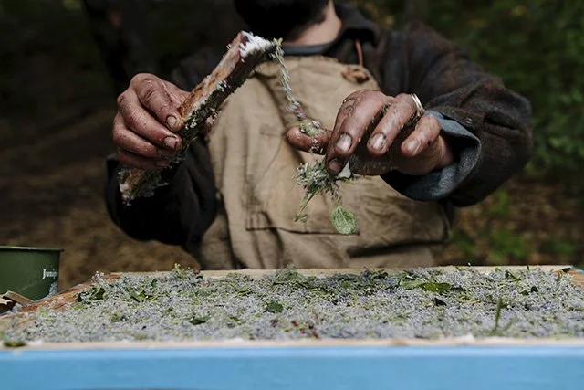 Person spreading resin with a tool onto a surface outdoors