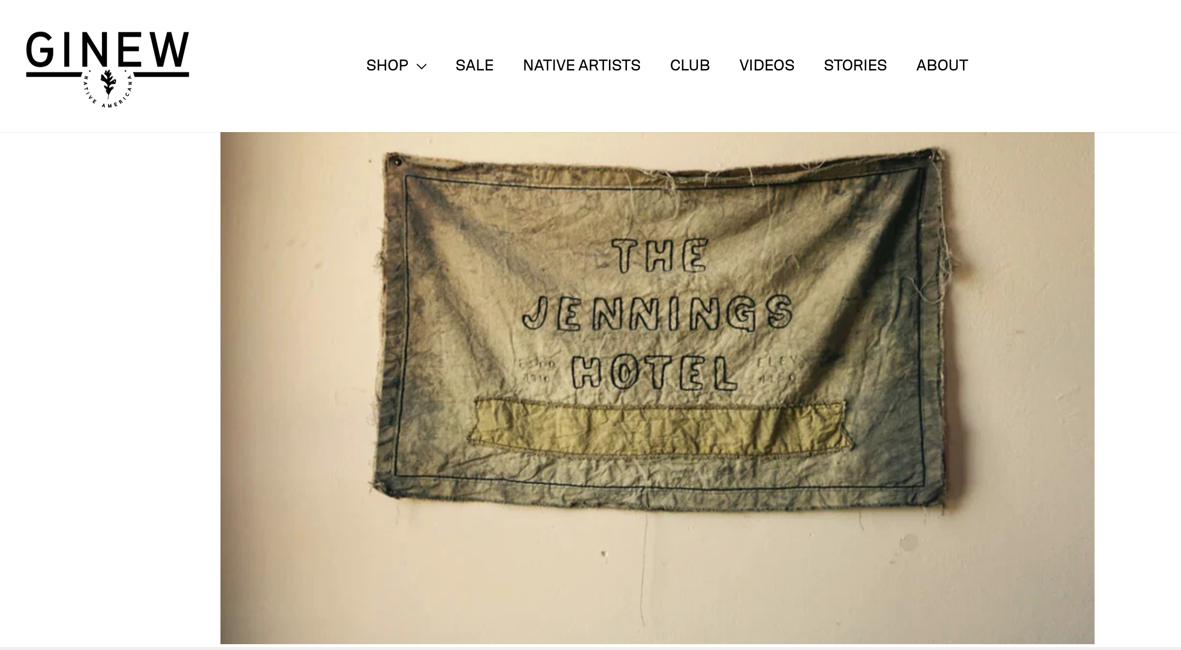 A fabric banner hanging on a wall, stitched with the words 'THE JENNINGS HOTEL' and outlined with a simple border.