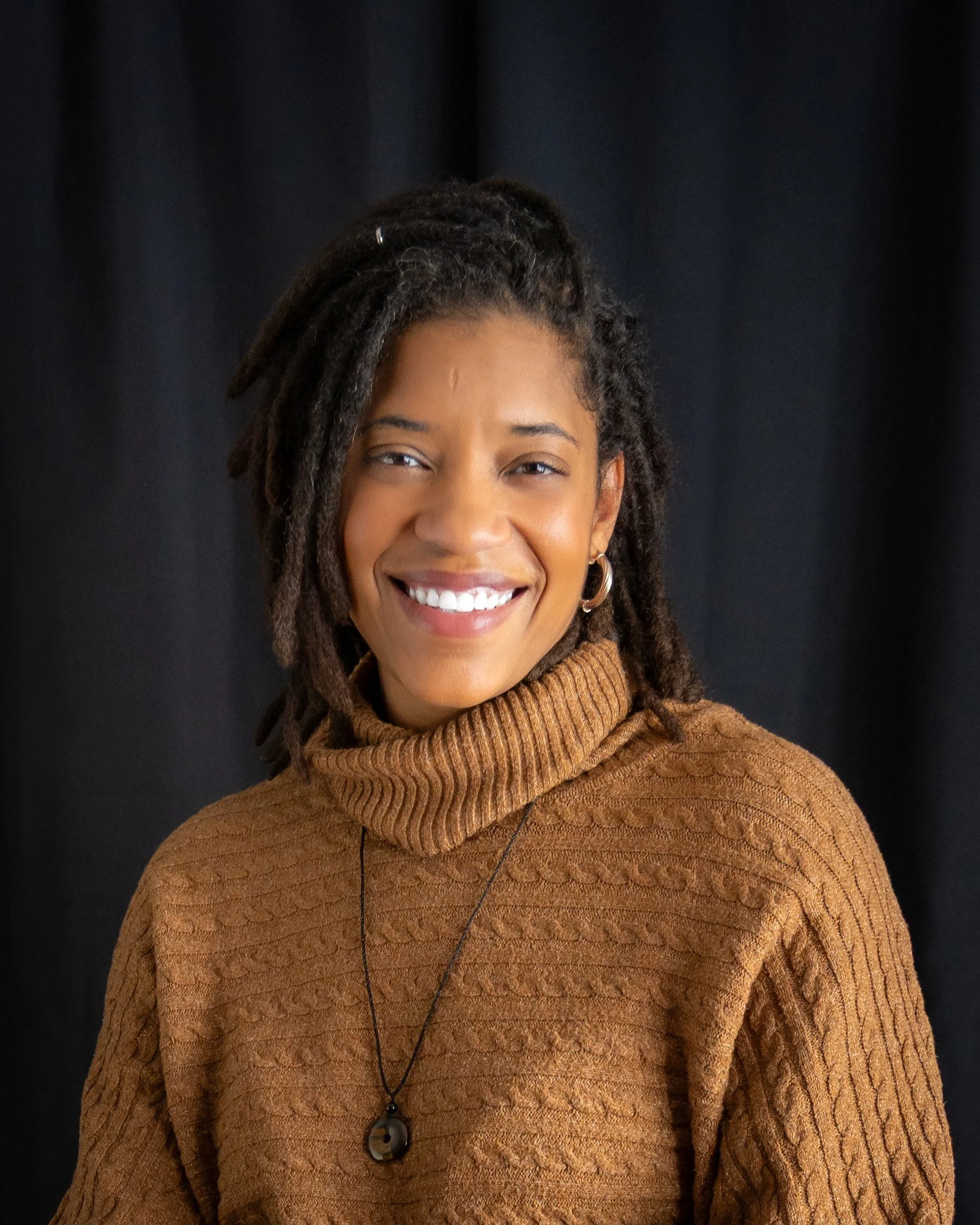headshot of smiling black woman with braids