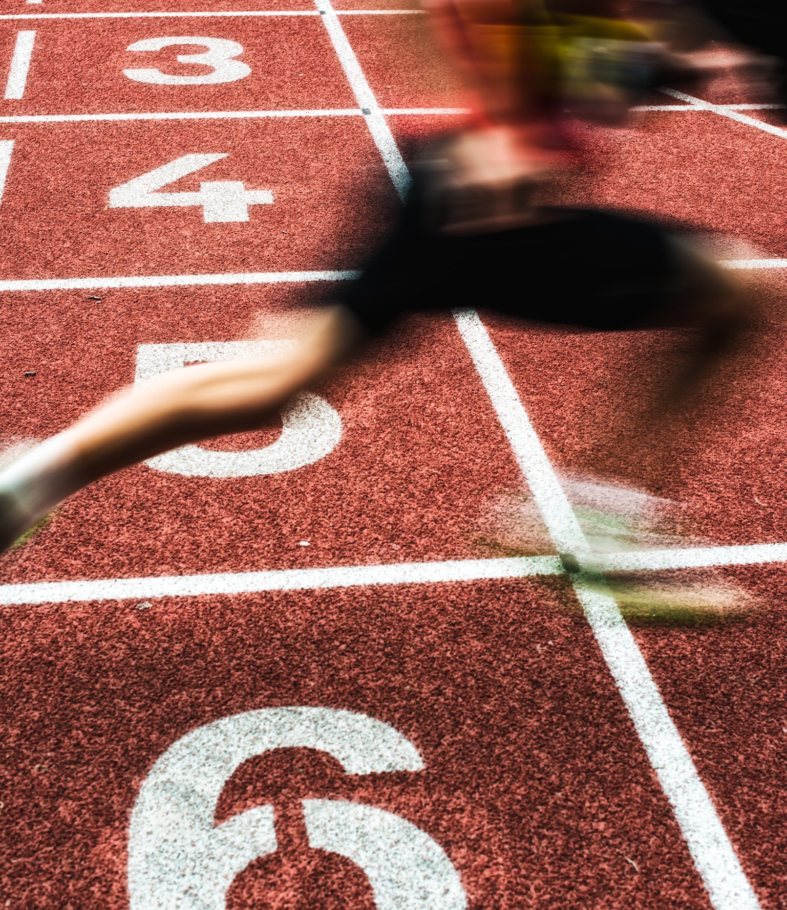 Línea de salida de la pista de atletismo con estaciones numeradas del 2 al 4, vista desde el suelo