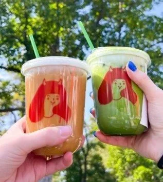 Two cups of matcha coffee in toast position.