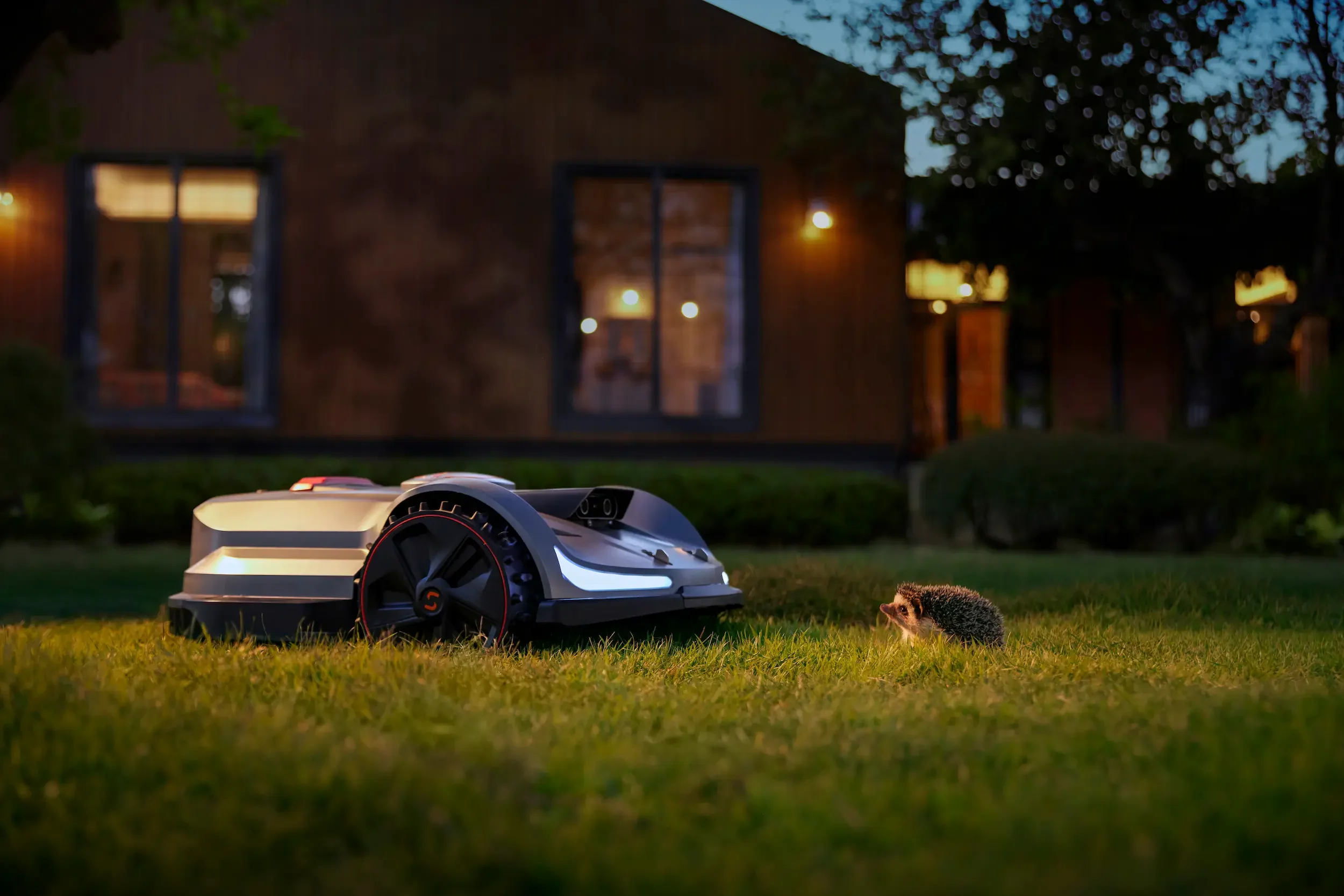 Sunseeker X Series robotic mower operating at dusk with obstacle detection on a residential lawn