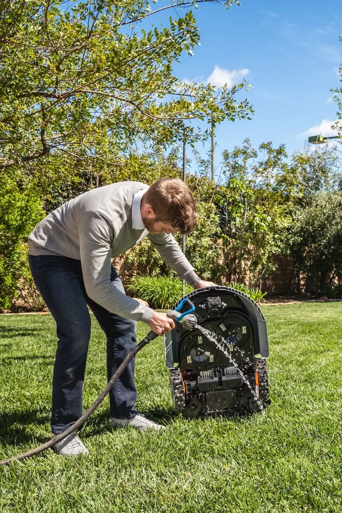 Technician servicing a Sunseeker X Series robotic mower as part of a managed mowing program