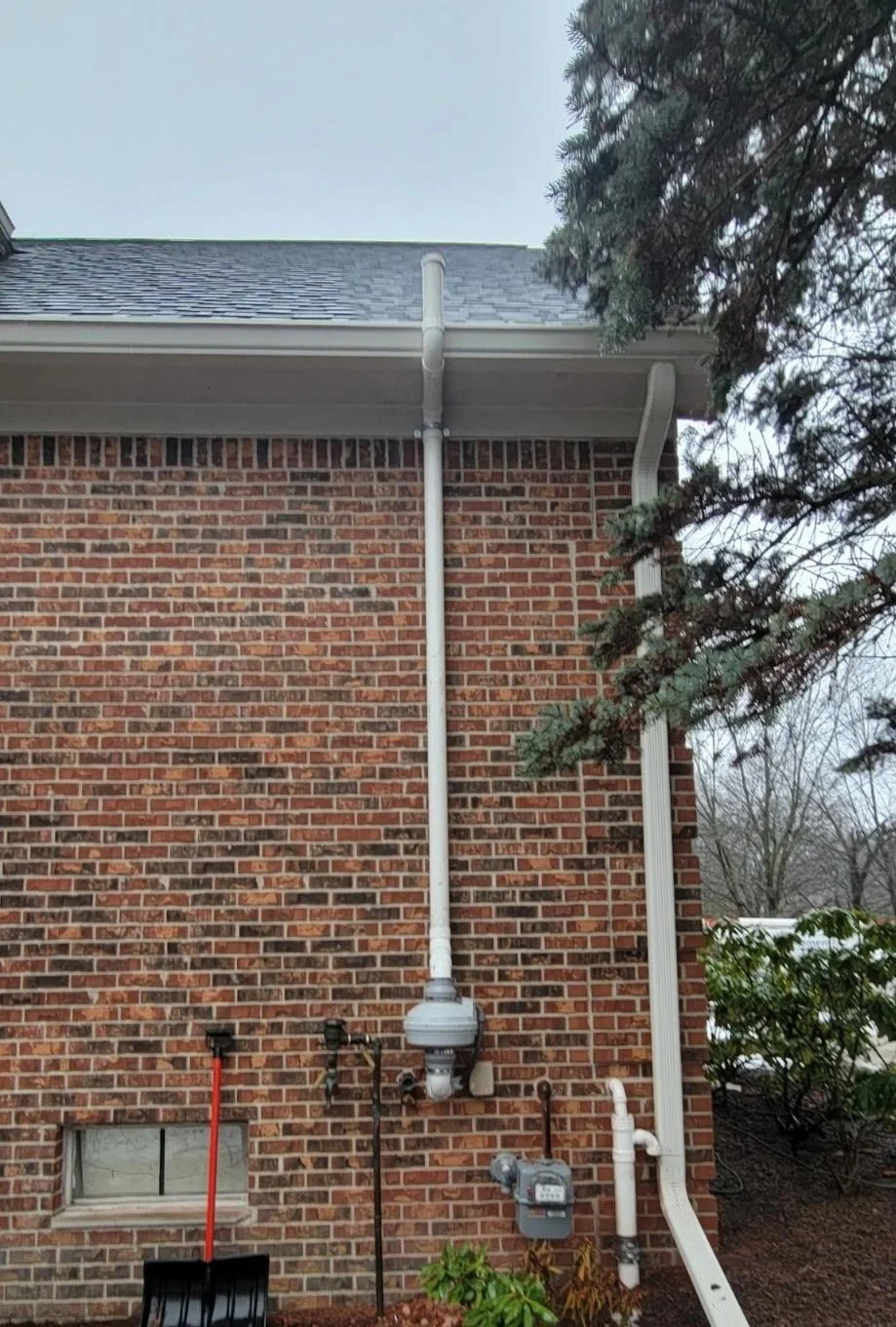 Residential radon mitigation vent pipe and fan installed on home exterior