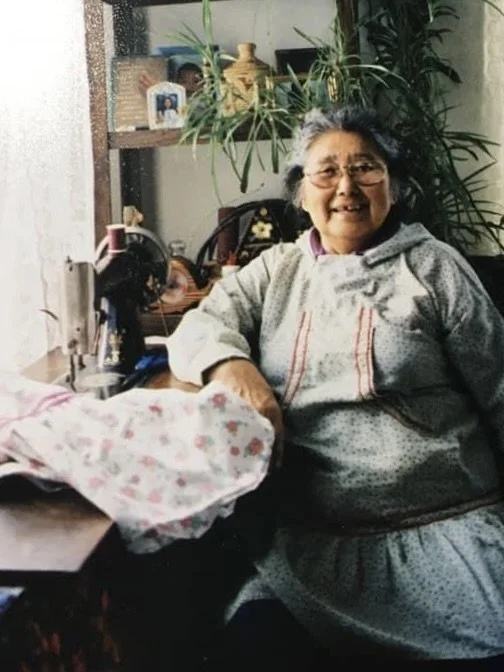 Bethel elder in her home smiling next to sewing machine