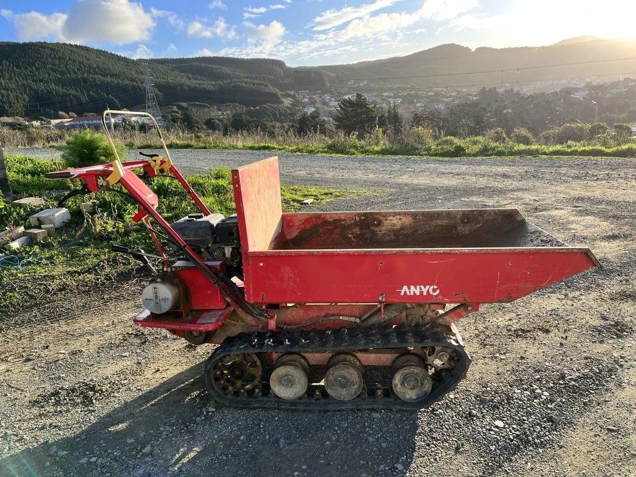 Just Grass NZ and DigTight limited Canycom BFP602 tracked wheelbarrow side view on site rolling hills and sunset in background