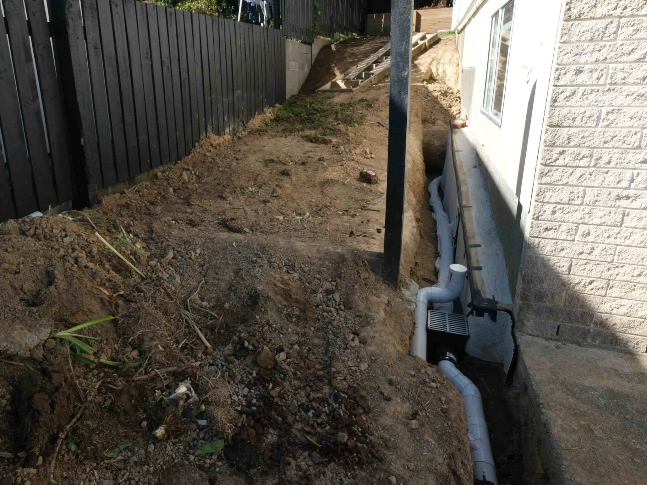 Treanhing and drainage installation along side of house
