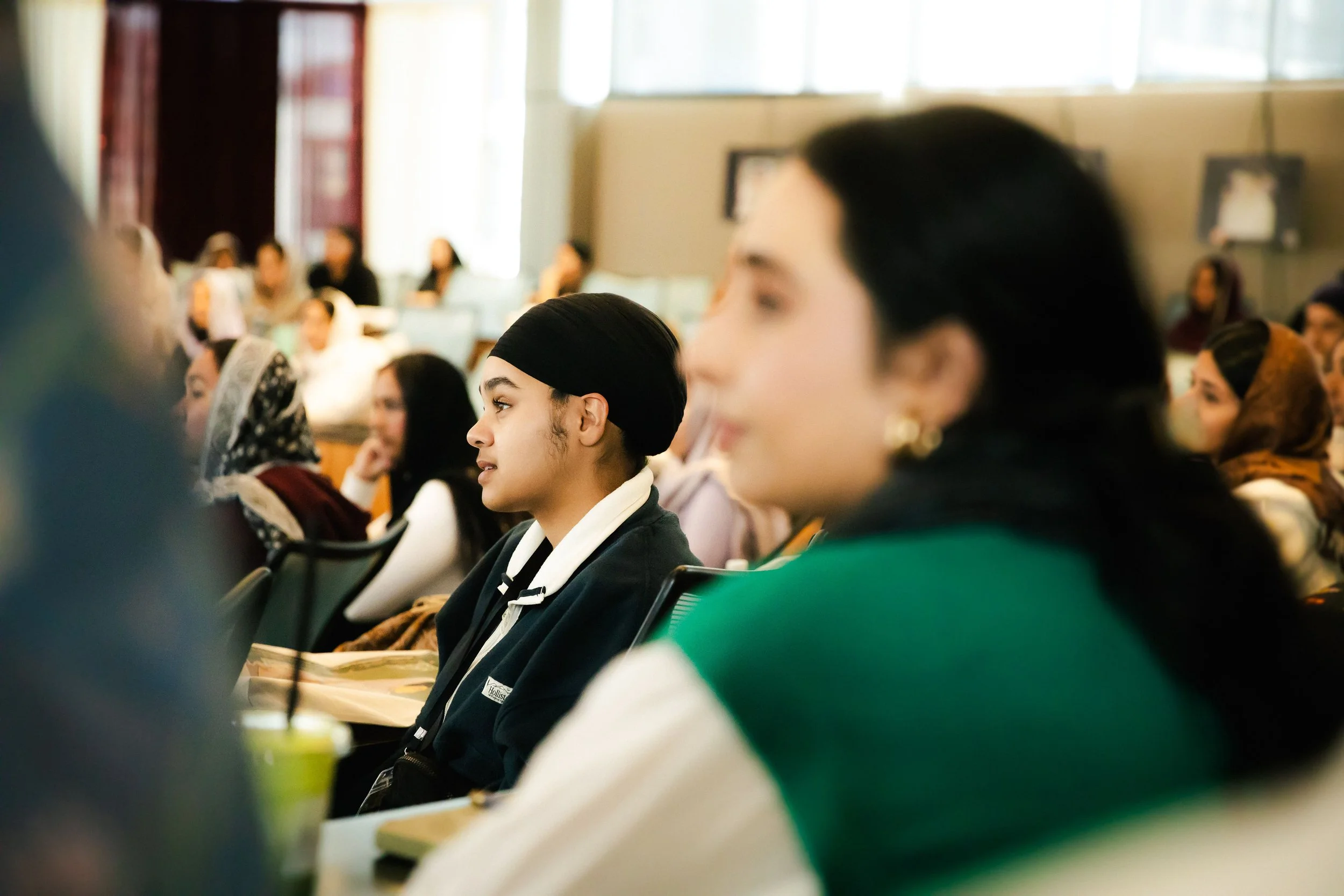 Students attending a classroom lecture or seminar, sitting attentively and listening.