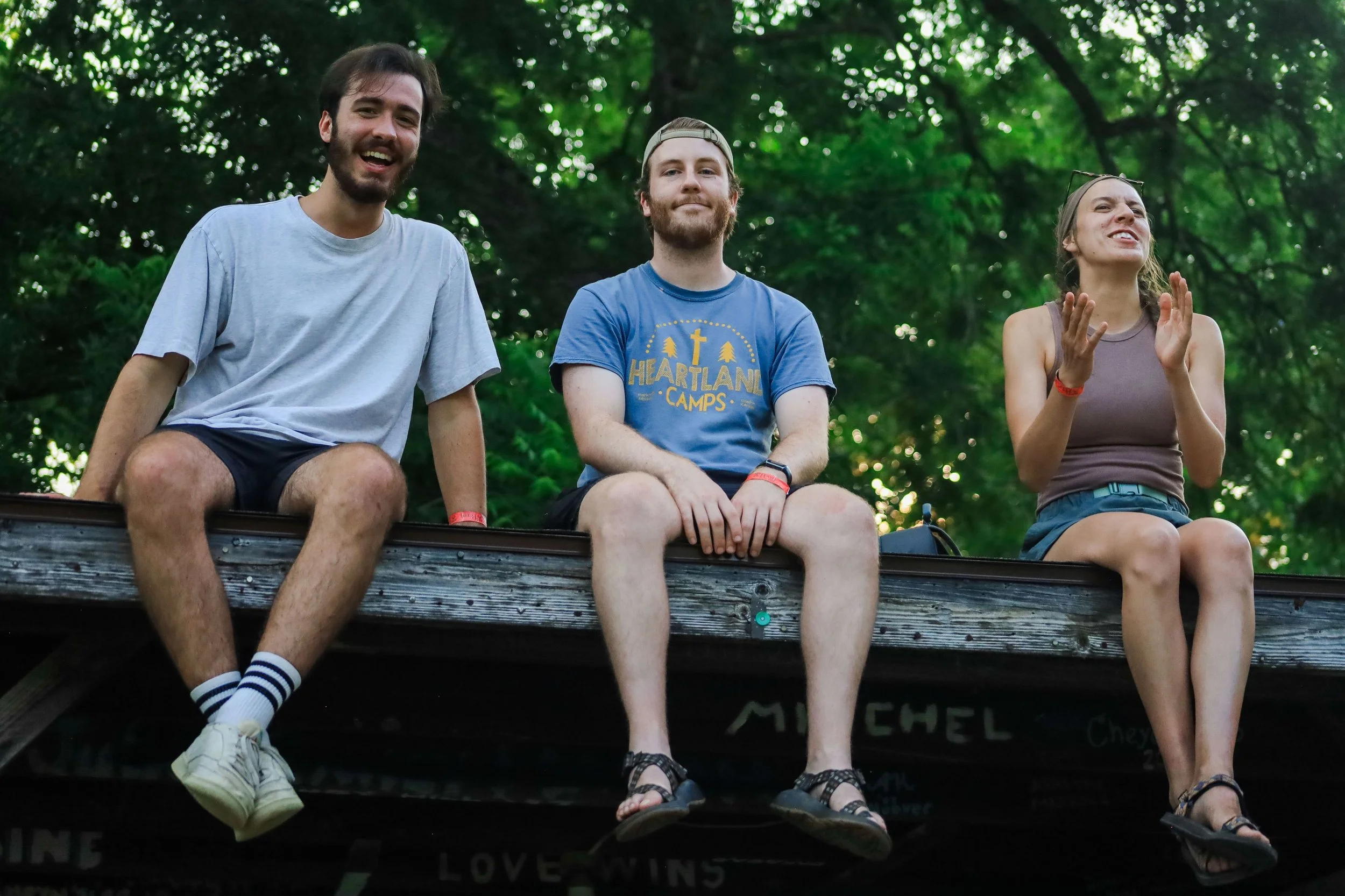 Heartland Christian Camp Paid Gap Year Internship Men and Women Sitting Together on a roof and smiling Outside Near Kansas City, Missouri
