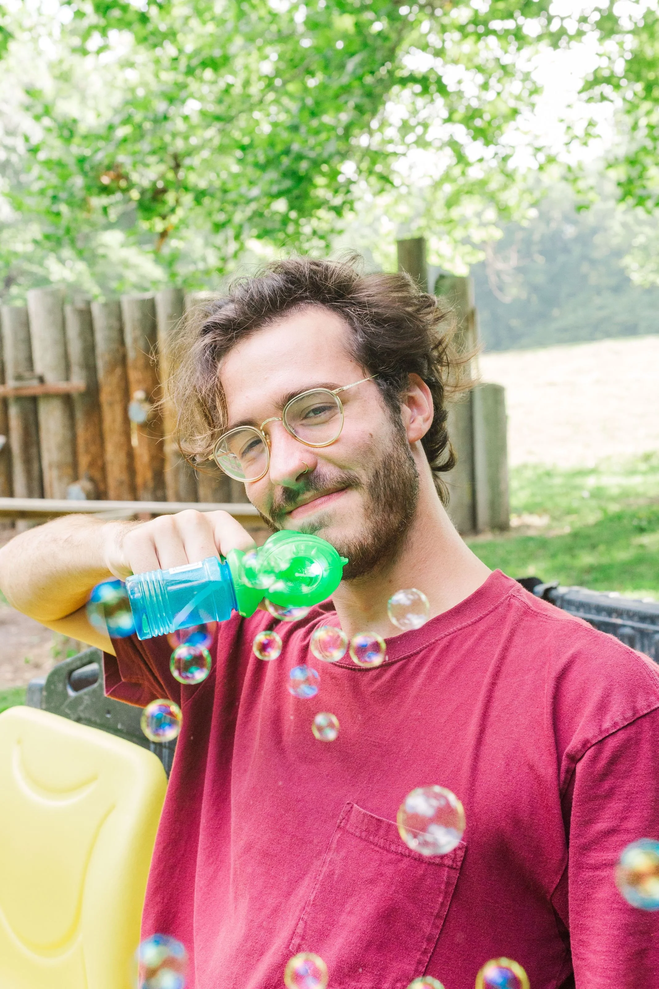 Heartland Christian Camp Paid Gap Year Internship man standing and smiling with a bubble gun Outside Near Kansas City, Missouri