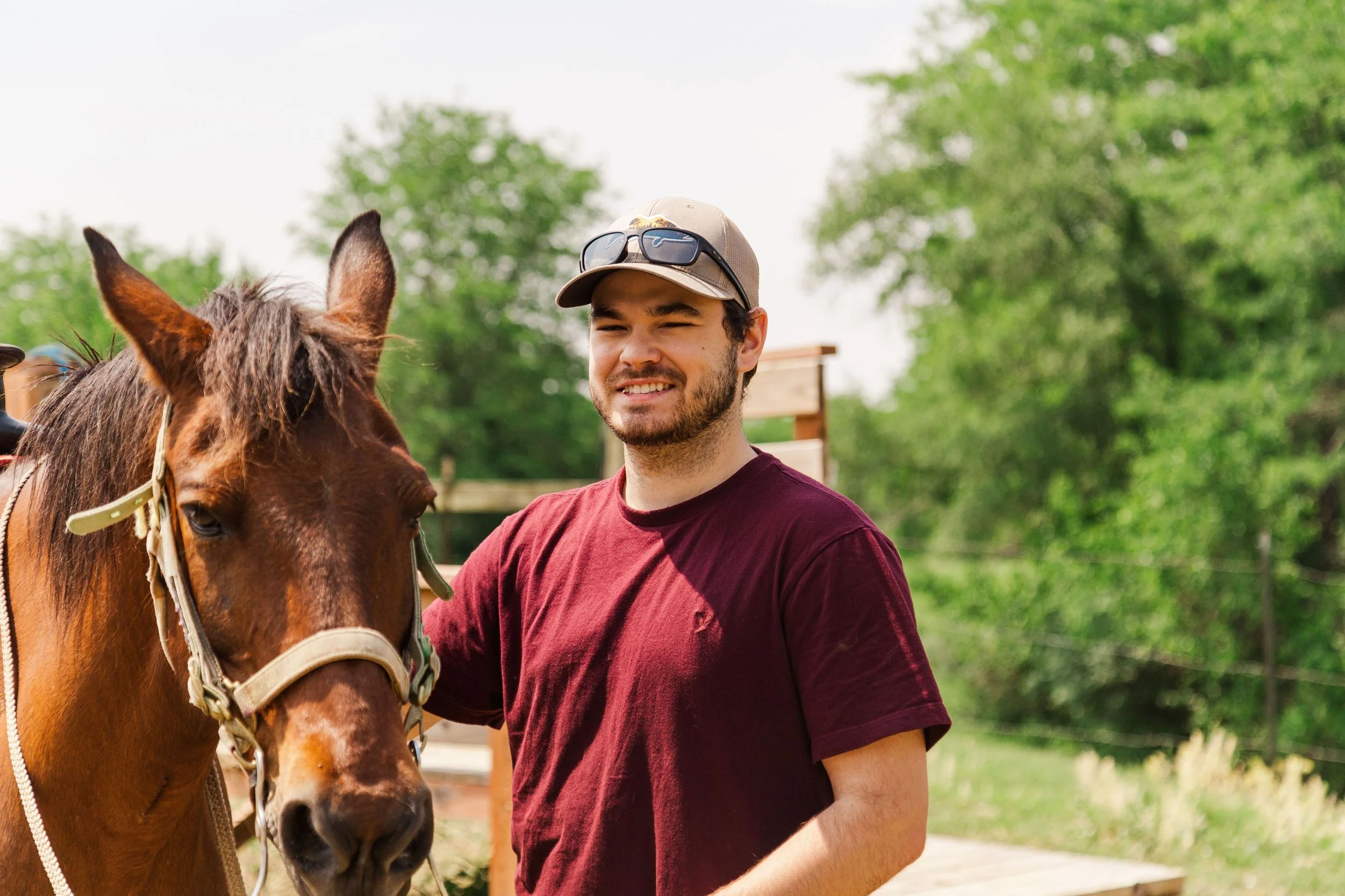 Heartland Christian Camp Paid Gap Year Internship man standing and smiling with a horse Outside Near Kansas City, Missouri
