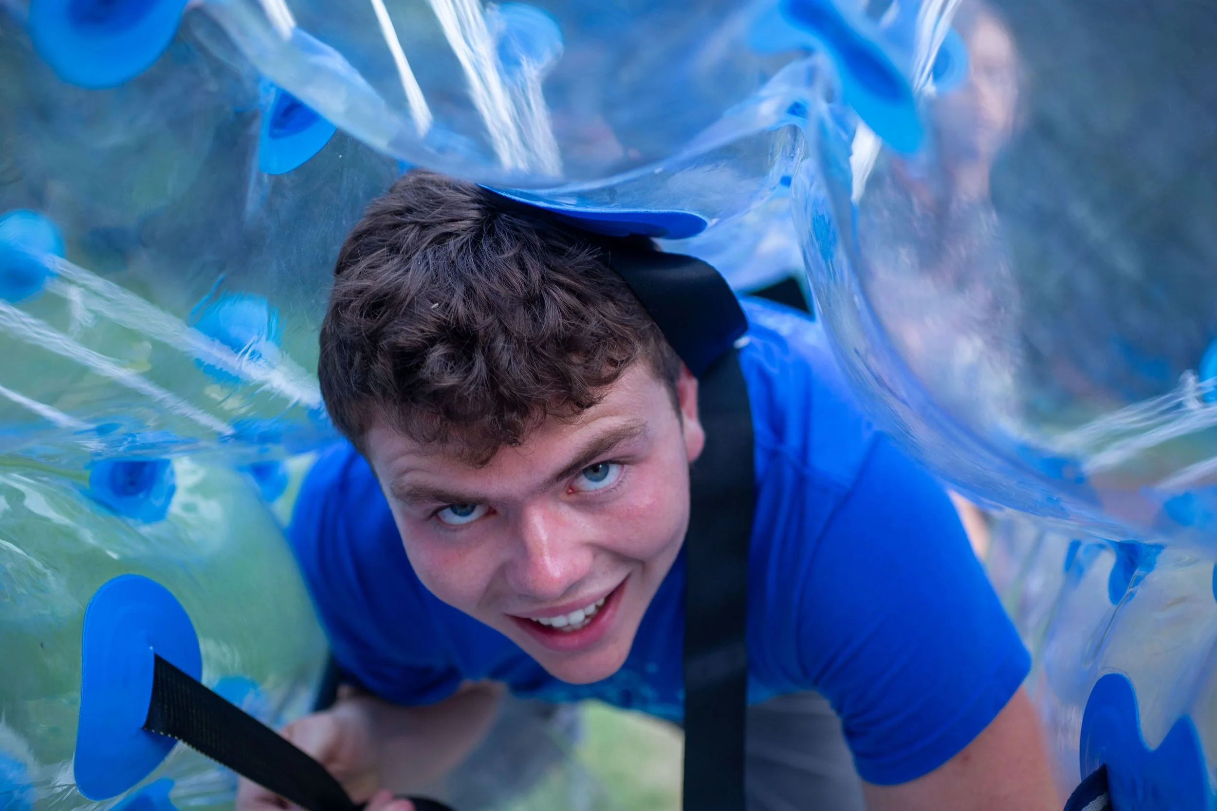 Heartland Christian Camp Paid Gap Year Internship man inside a blow up ball and smiling Outside Near Kansas City, Missouri
