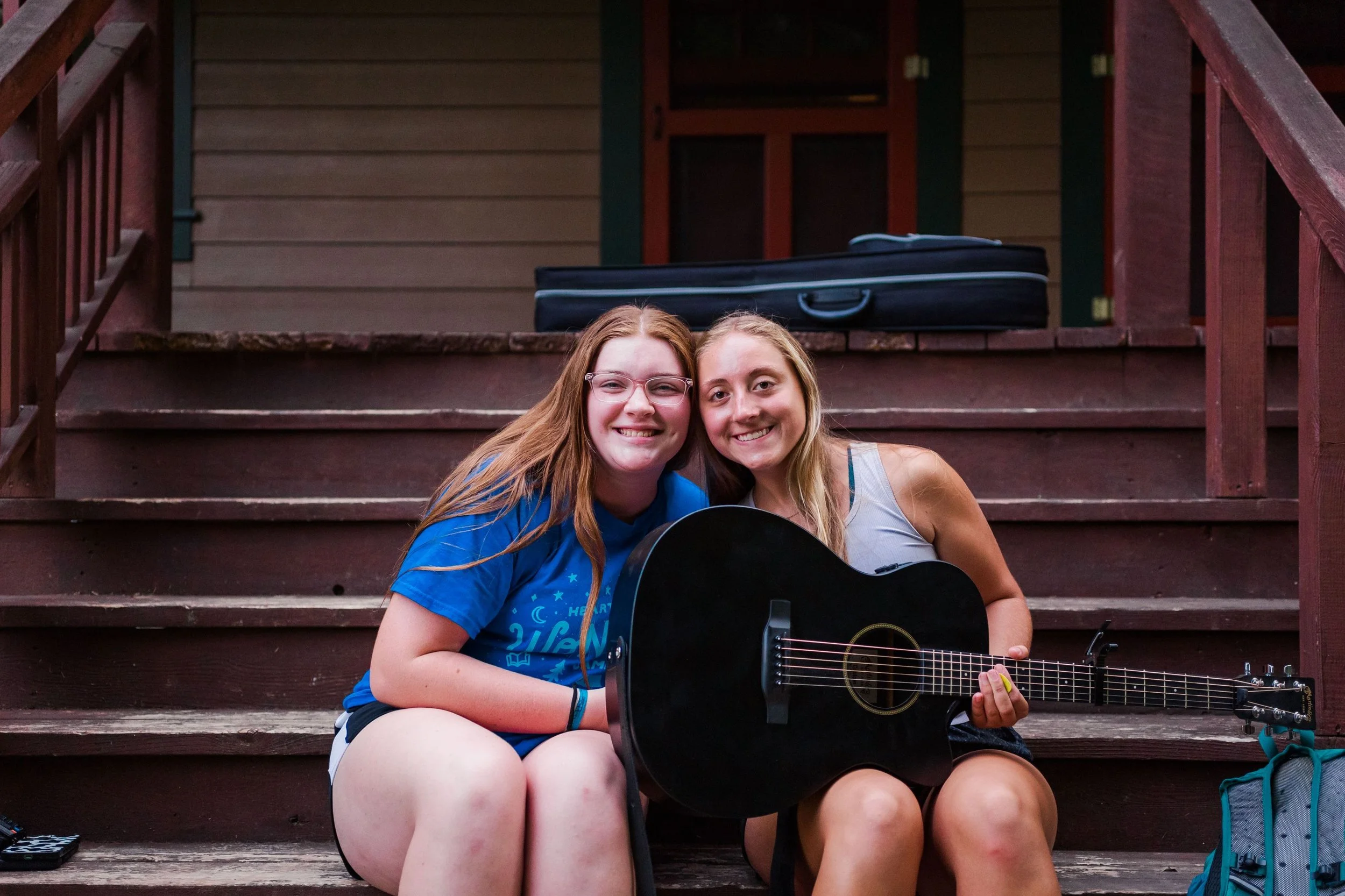 Heartland Christian Camp Paid Gap Year Internship Women Sitting Together with a guitar Outside Near Kansas City, Missouri