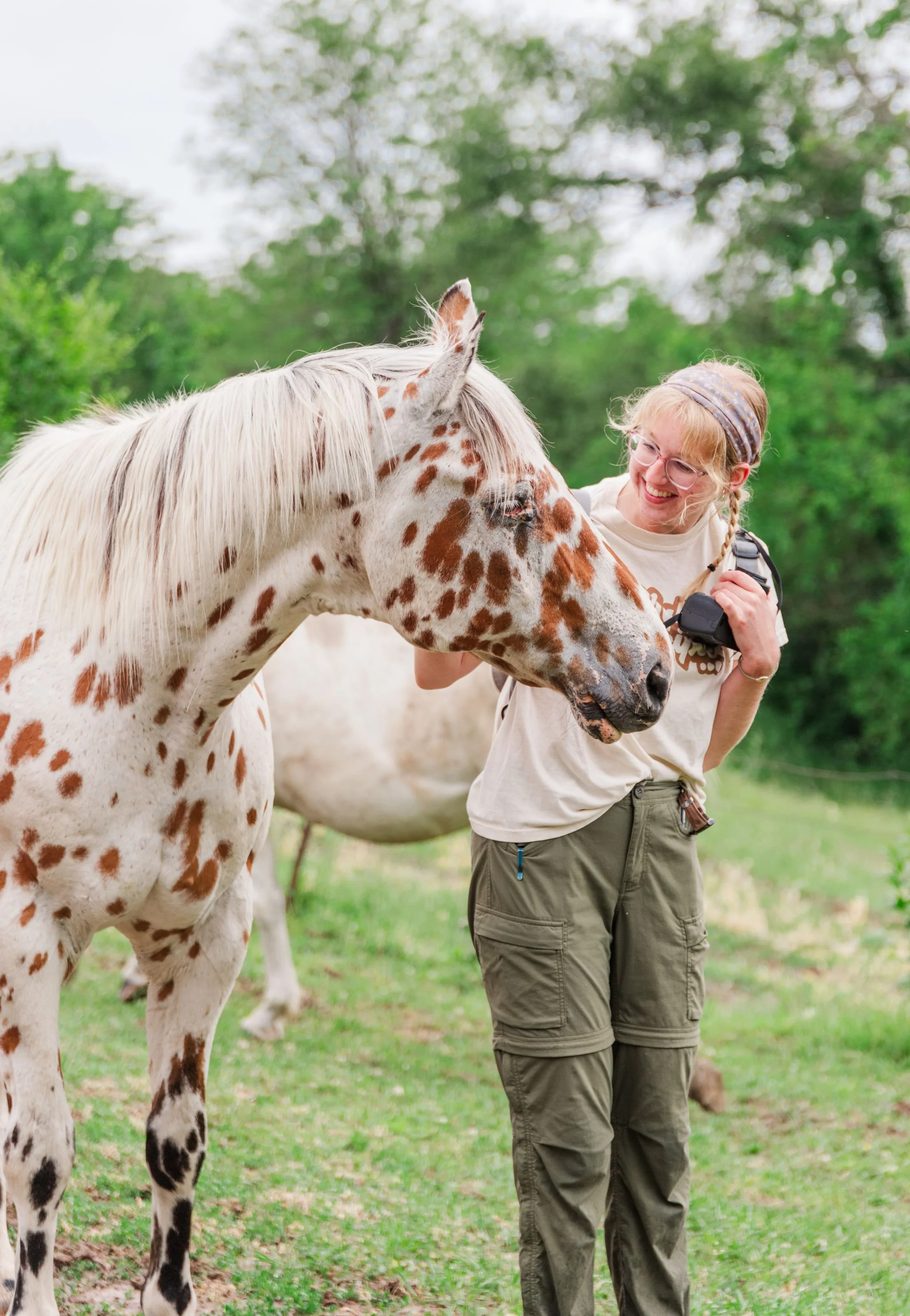 Heartland Christian Camp Paid Gap Year Internship woman standing and smiling with a horse Outside Near Kansas City, Missouri