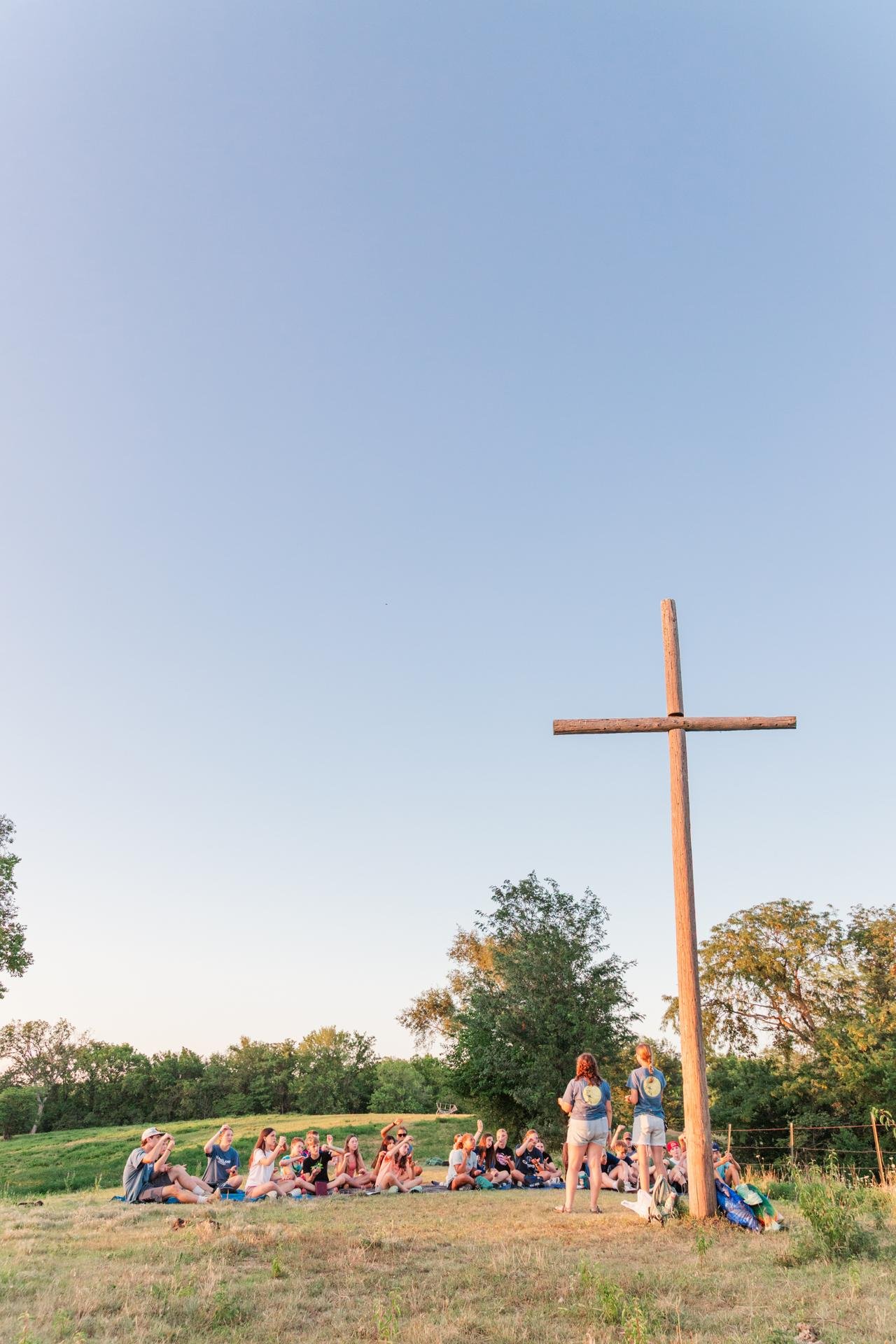 Heartland Christian Camp Paid Gap Year Internship Men and Women teaching kids about God near a cross Outside Near Kansas City, Missouri
