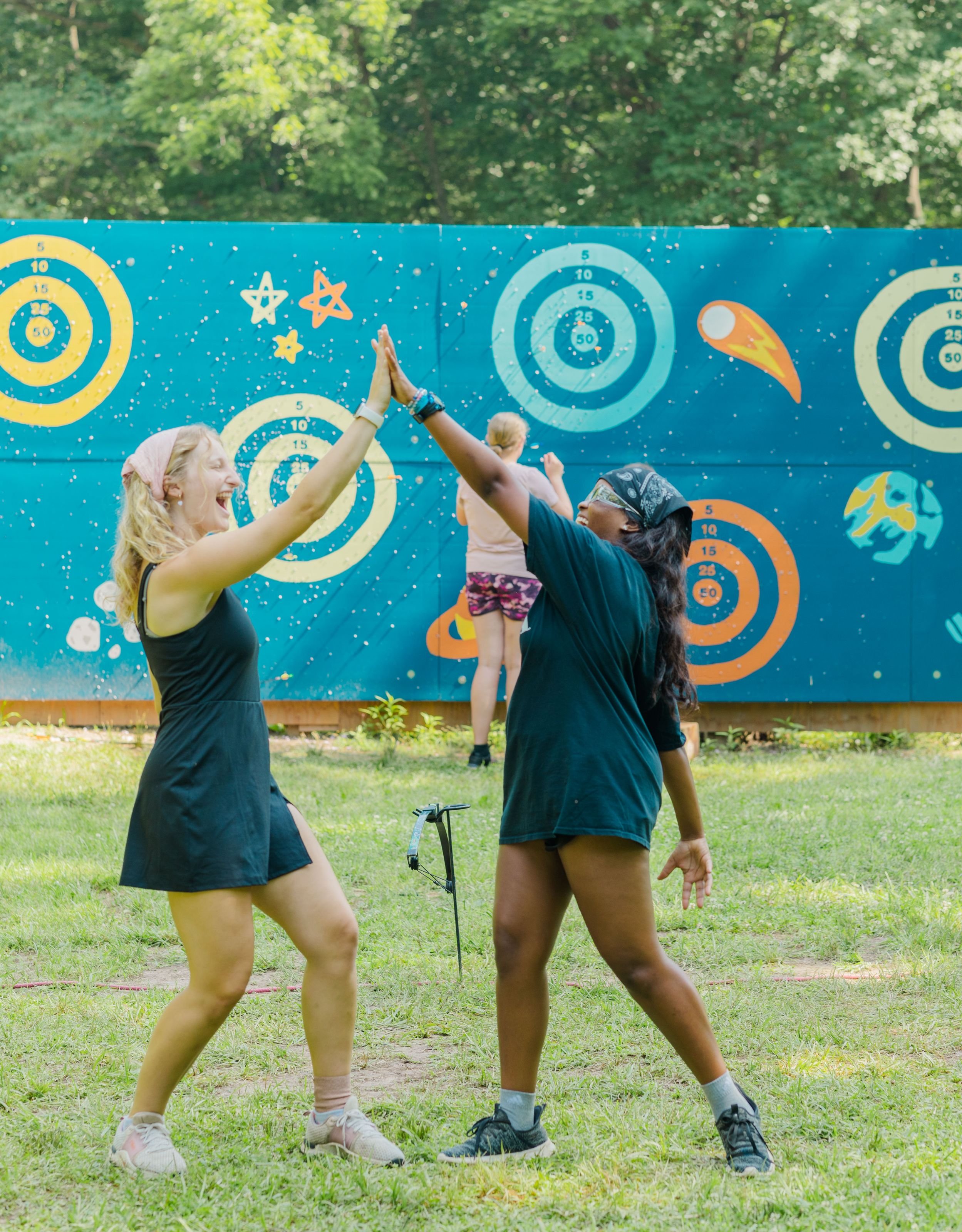 Heartland Christian Camp Paid Gap Year Internship women high fiving and smiling together Outside Near Kansas City, Missouri