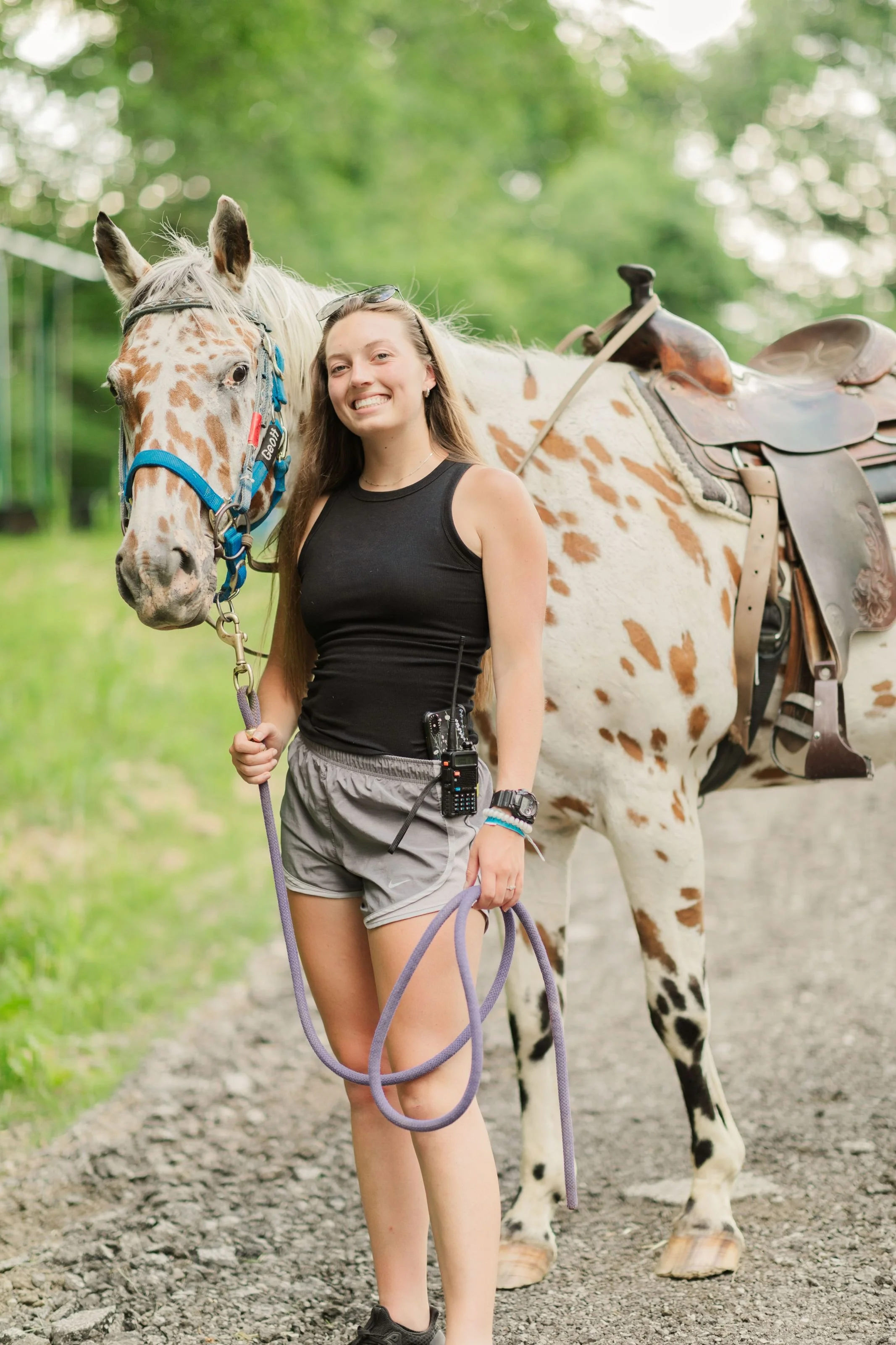 Heartland Christian Camp Paid Gap Year Internship woman standing and smiling with a horse Outside Near Kansas City, Missouri