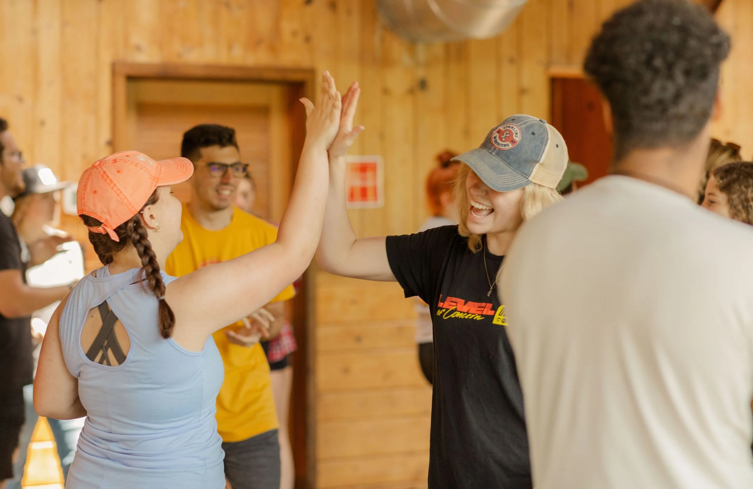 Heartland Christian Camp Paid Gap Year Internship Men and Women Standing and Smiling while clapping Together indoors Near Kansas City, Missouri