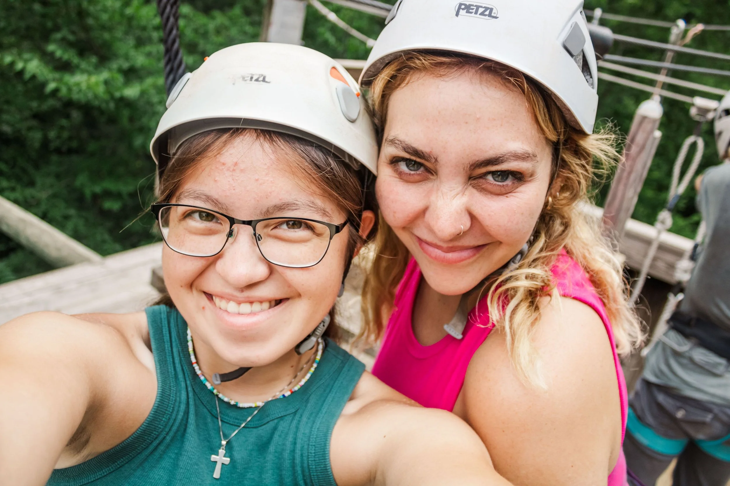 Heartland Christian Camp Paid Gap Year Internship women standing and smiling in helmets on a high ropes course together Outside Near Kansas City, Missouri