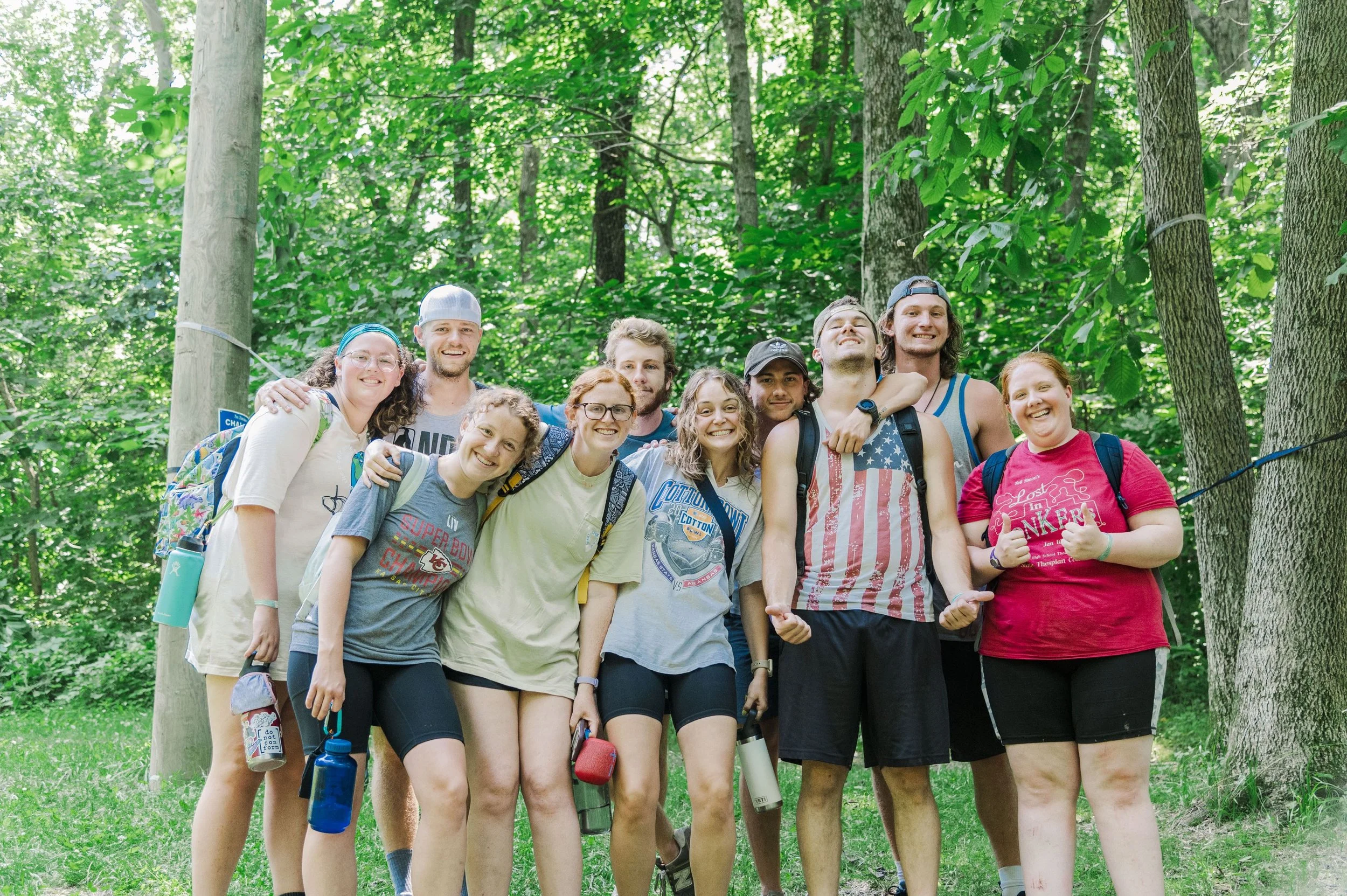 Heartland Christian Camp Paid Gap Year Internship Men and Women standing and smiling in a forest Together Outside Near Kansas City, Missouri