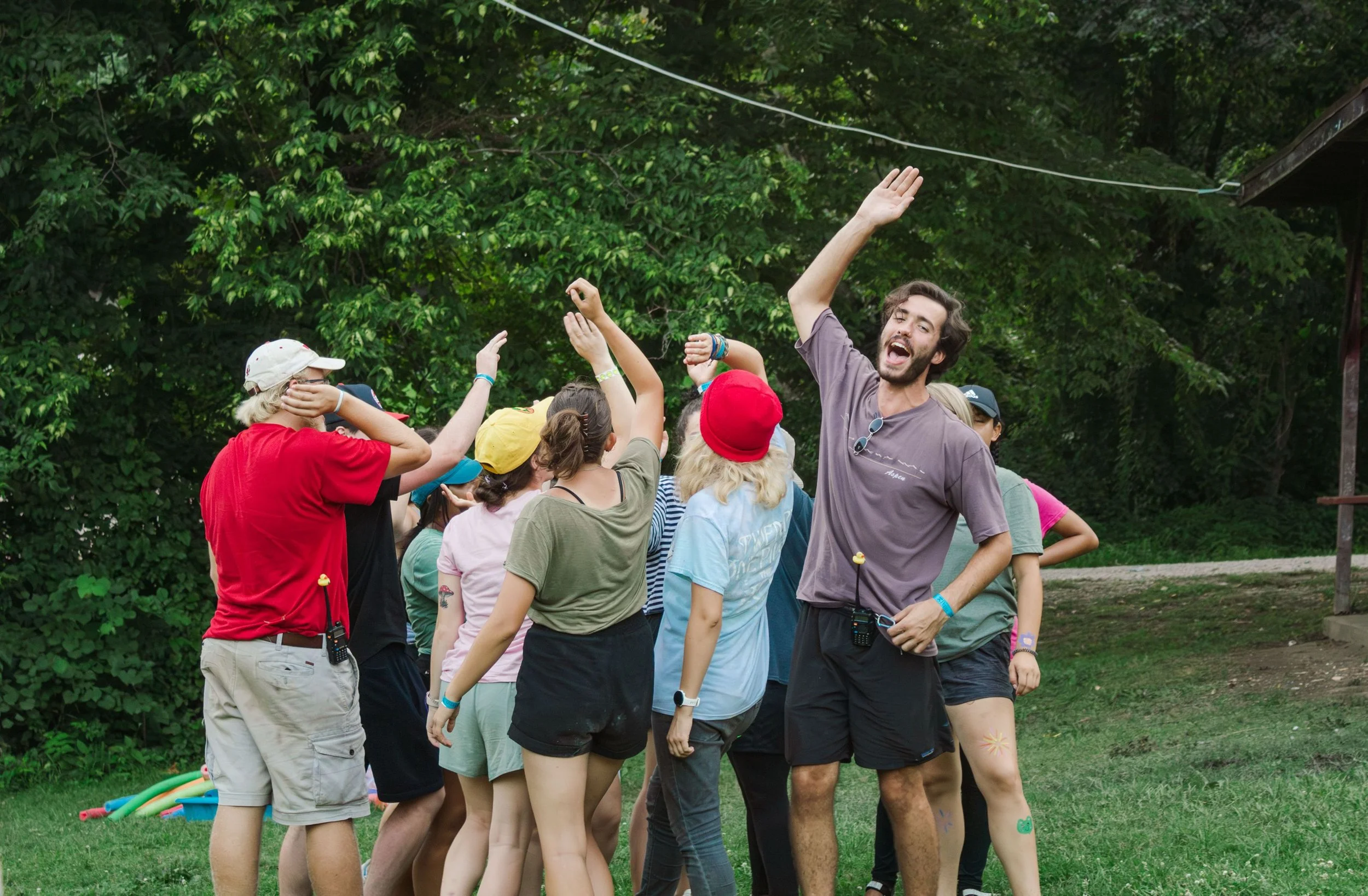 Heartland Christian Camp Paid Gap Year Internship Men and Women Standing and Smiling Together in a circle with their arms up Outside Near Kansas City, Missouri