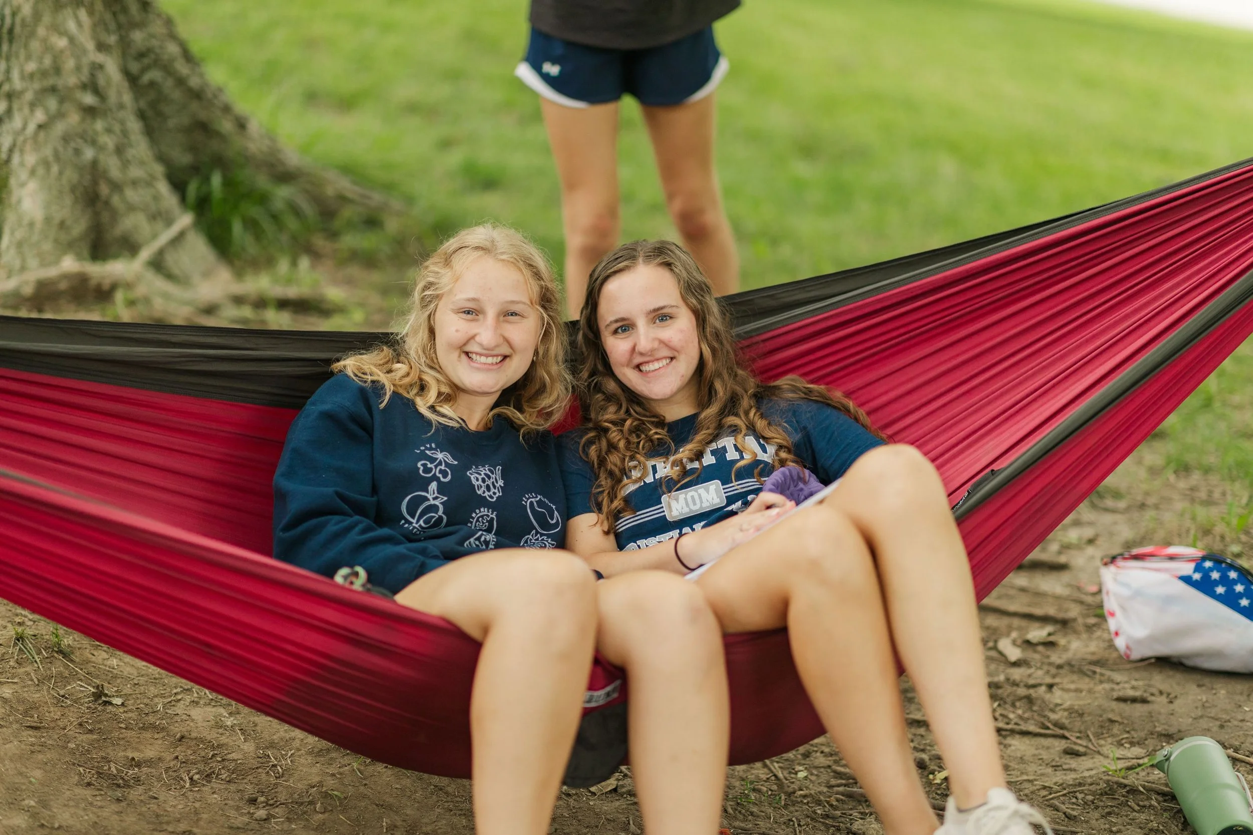 Heartland Christian Camp Paid Gap Year Internship women sitting in a hammock and smiling Outside Near Kansas City, Missouri