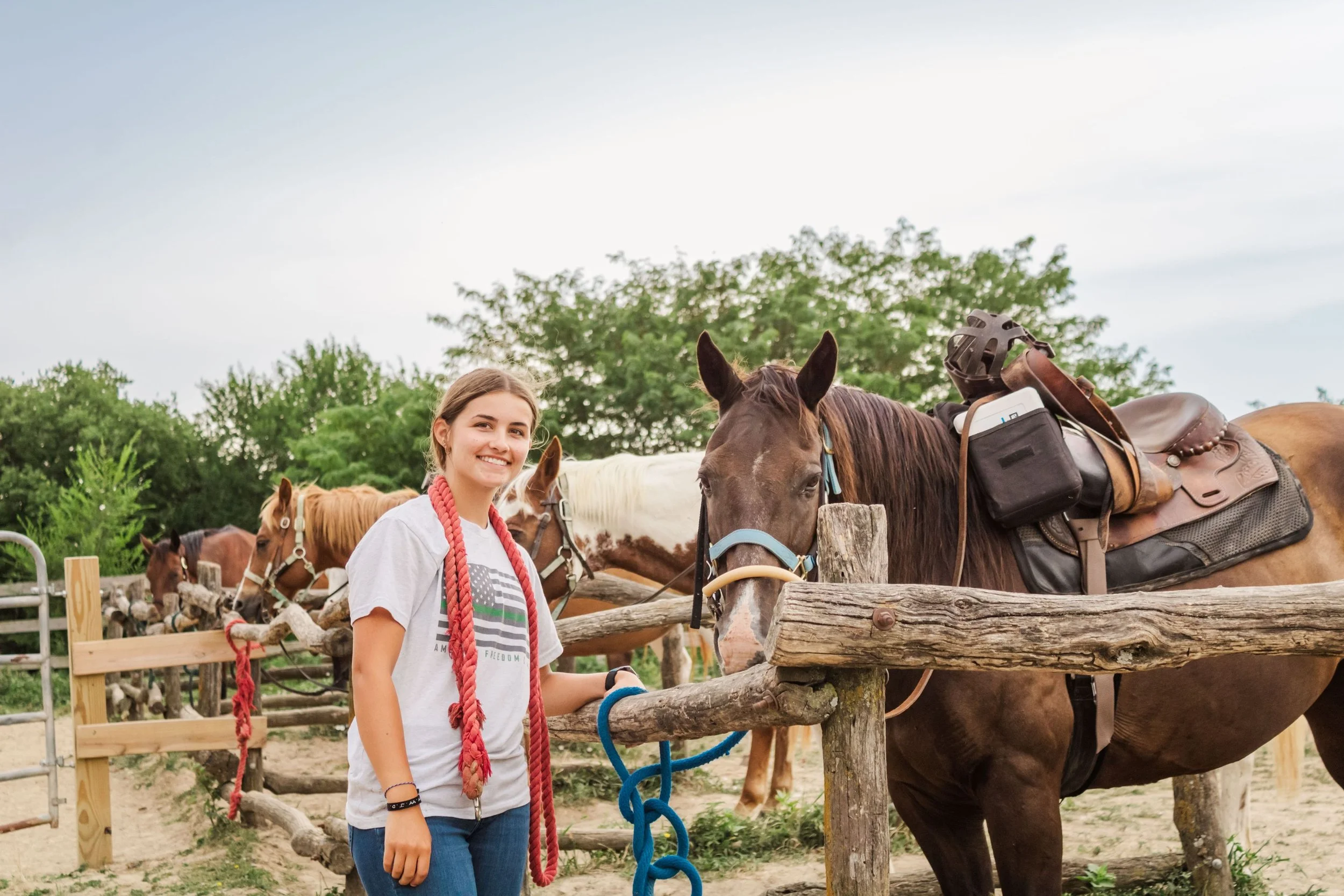 Heartland Christian Camp Paid Gap Year Internship woman standing and smiling with a horse Outside Near Kansas City, Missouri