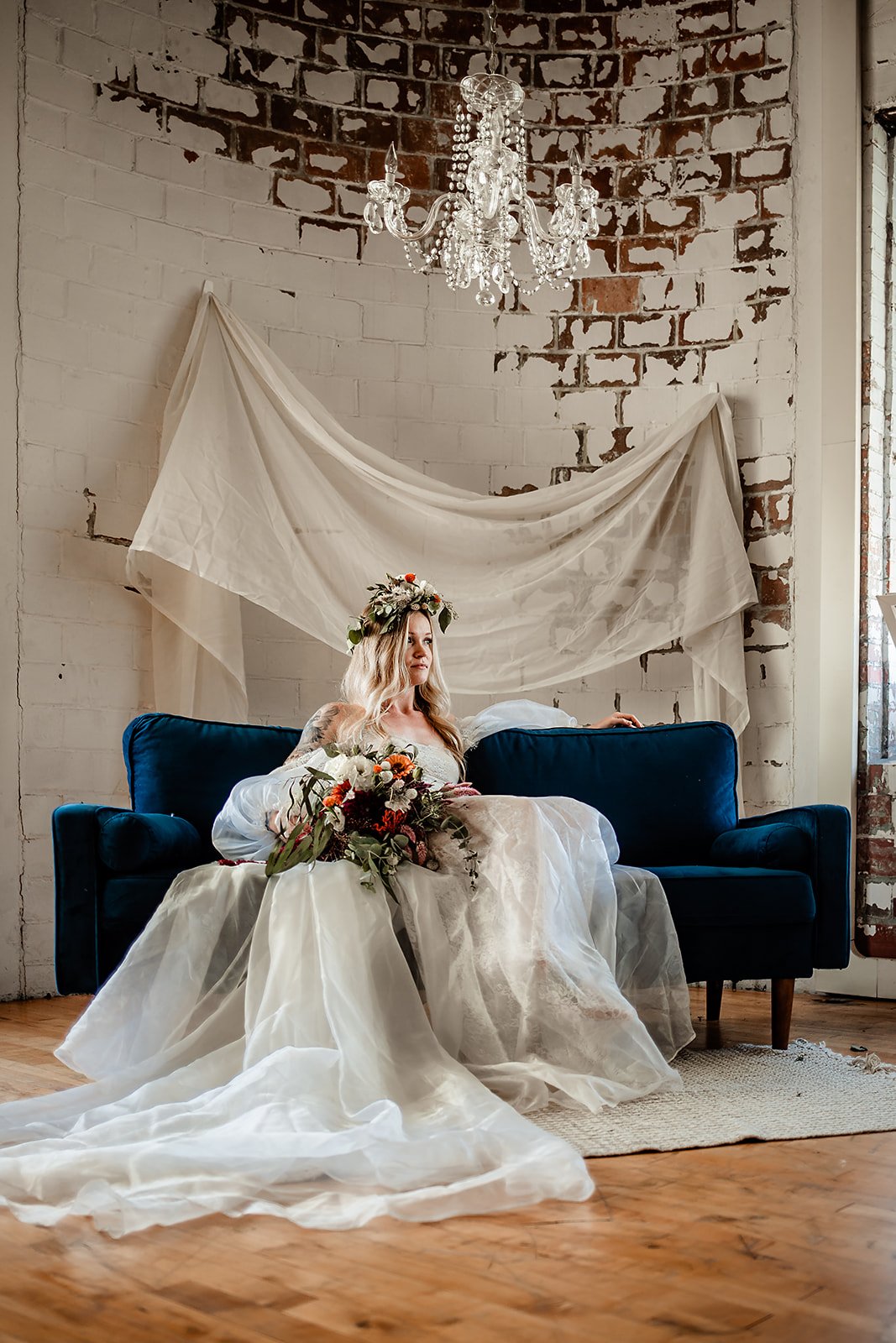 Wedding Portraits of Bride sitting on Couch with Florals