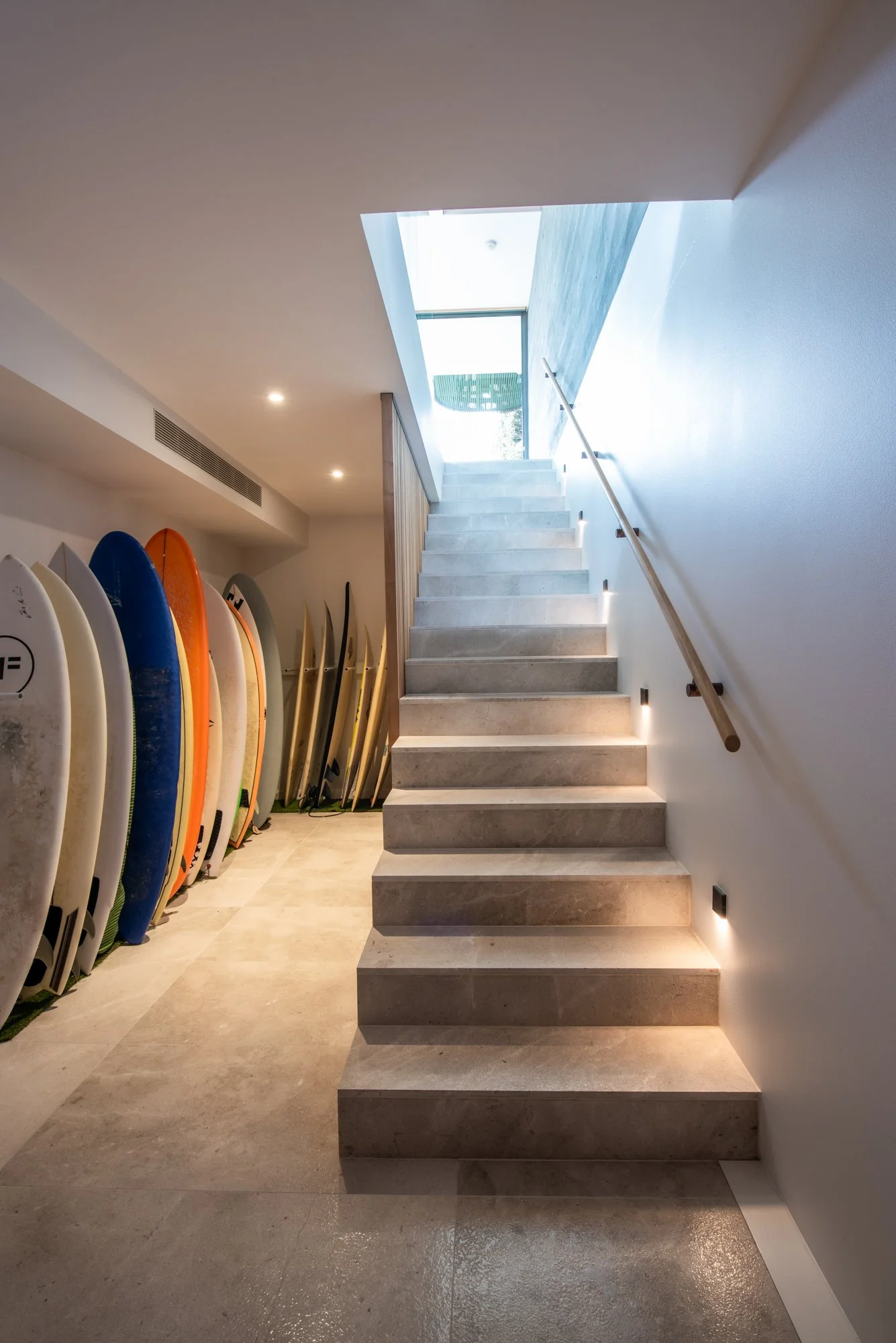 Basement staircase with surfboards and lighting