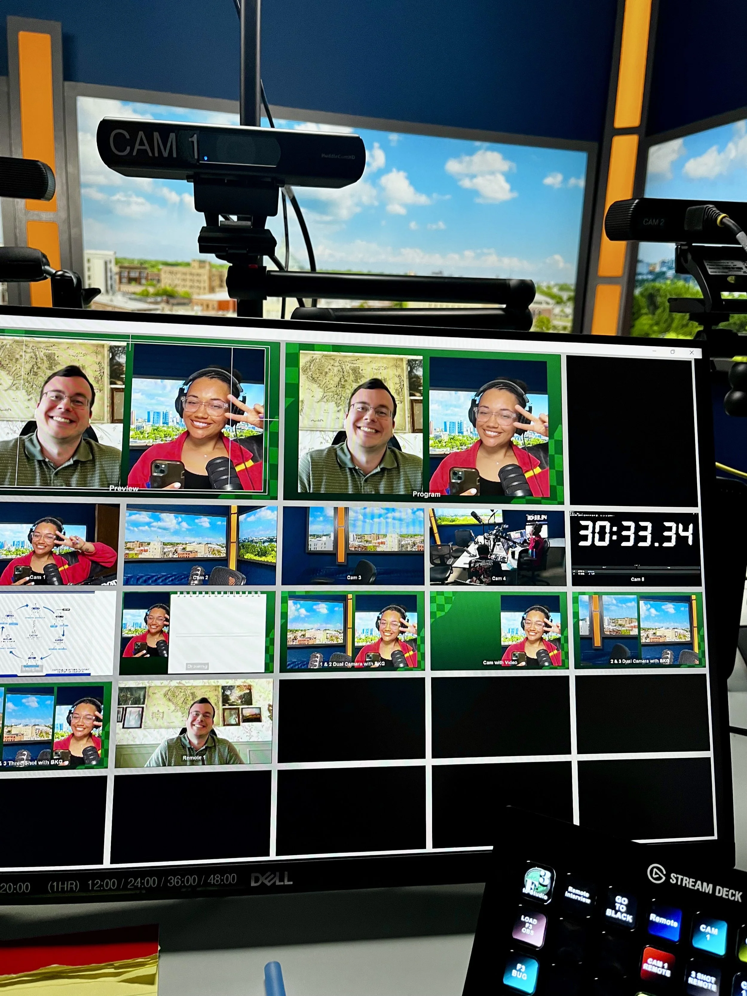 Close-up of host JaeVic wearing a colorful jacket and headphones while speaking into a RØDE microphone during a Finance Fitness Finesse (F3) podcast session, with a remote monitor displaying guest Nate Astle and a studio timer in the background.