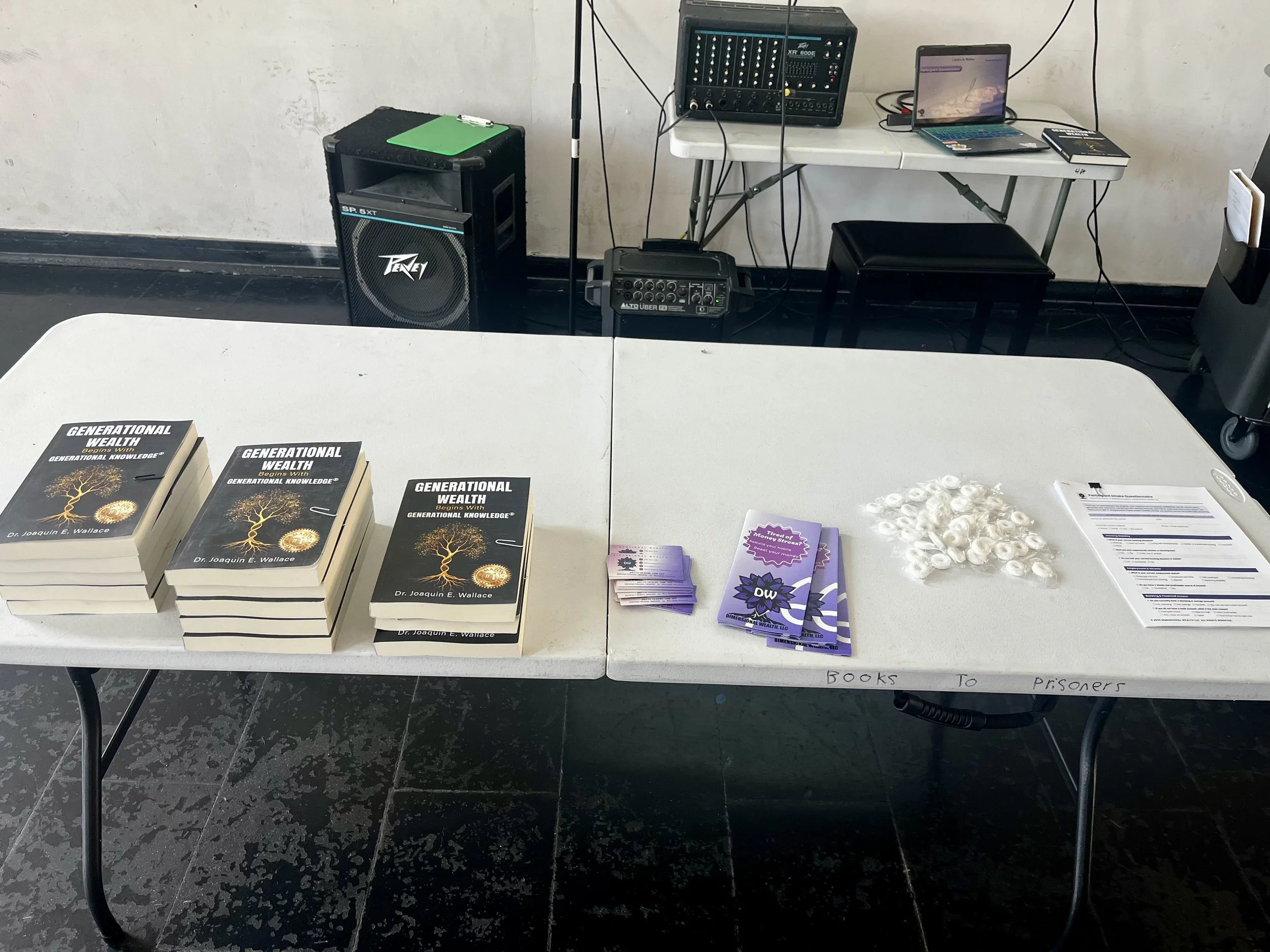  Packed with resources! Display table featuring copies of  Generational Wealth Begins With Generational Knowledge  by Dr. Joaquin E. Wallace for Jaelyn Vickery's presentation, alongside informational materials from Dimensional Wealth LLC and Cunningh